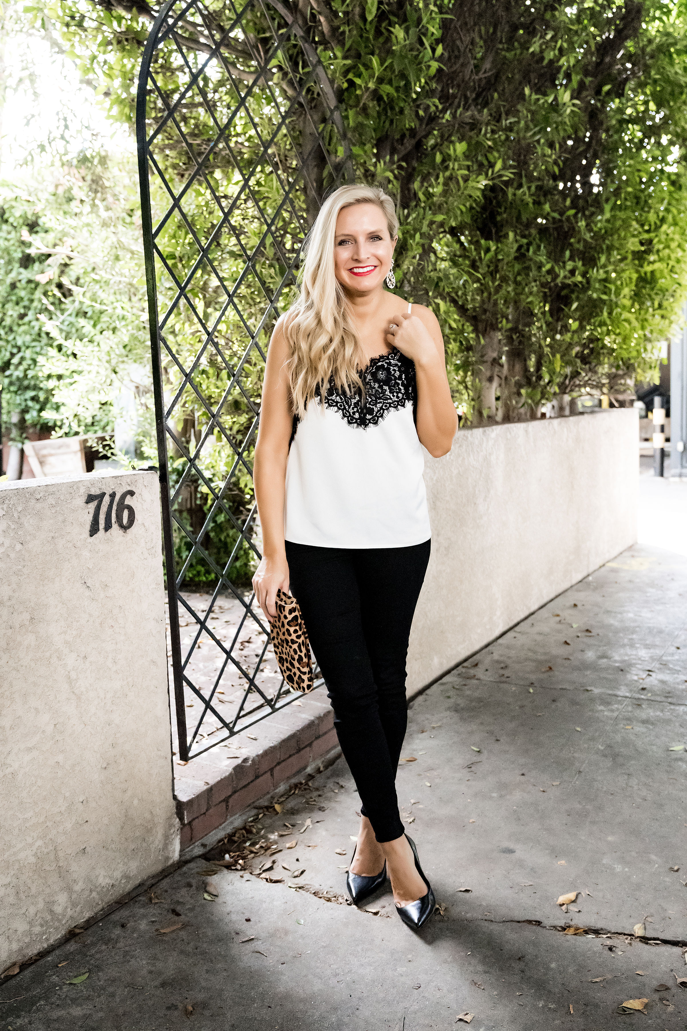 Gibson x Glam Collection Outfits featured by top Houston fashion blog, Fancy Ashley: a blonde woman walking wearing lace camisole, black denim jeans, black heels, leopard clutch