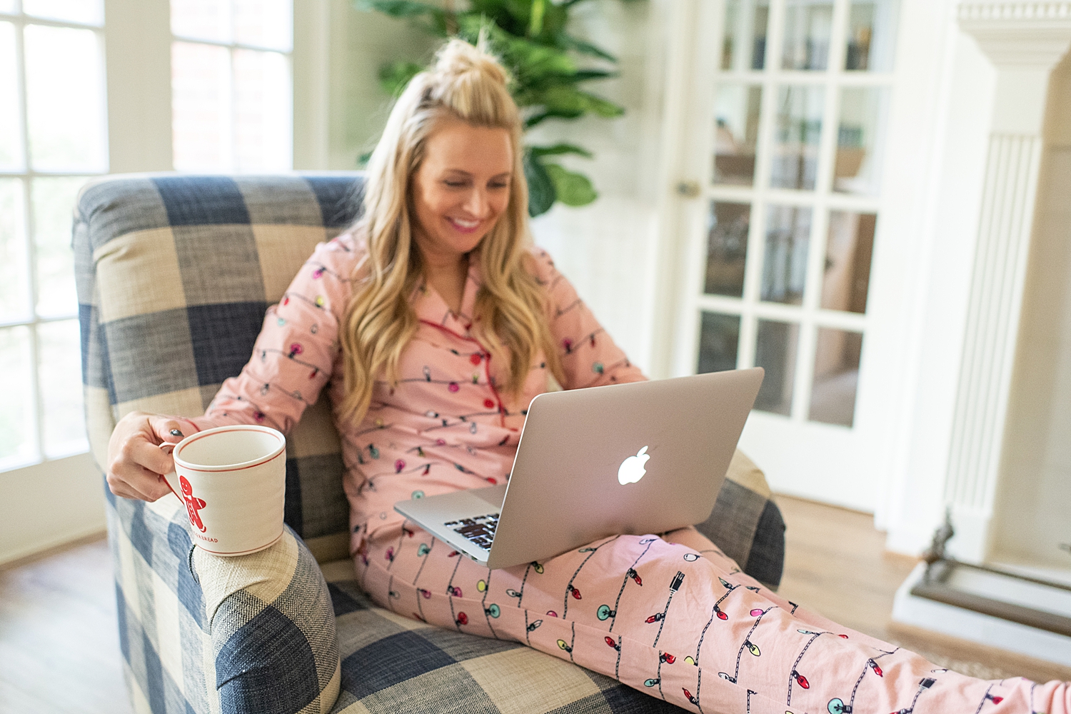 The Ultimate Cyber Monday Shopping Deals featured by top Houston life and style blogger, Fancy Ashley: picture of a blonde woman wearing Holidays PJs, sat on an armchair and looking at her Apple laptop