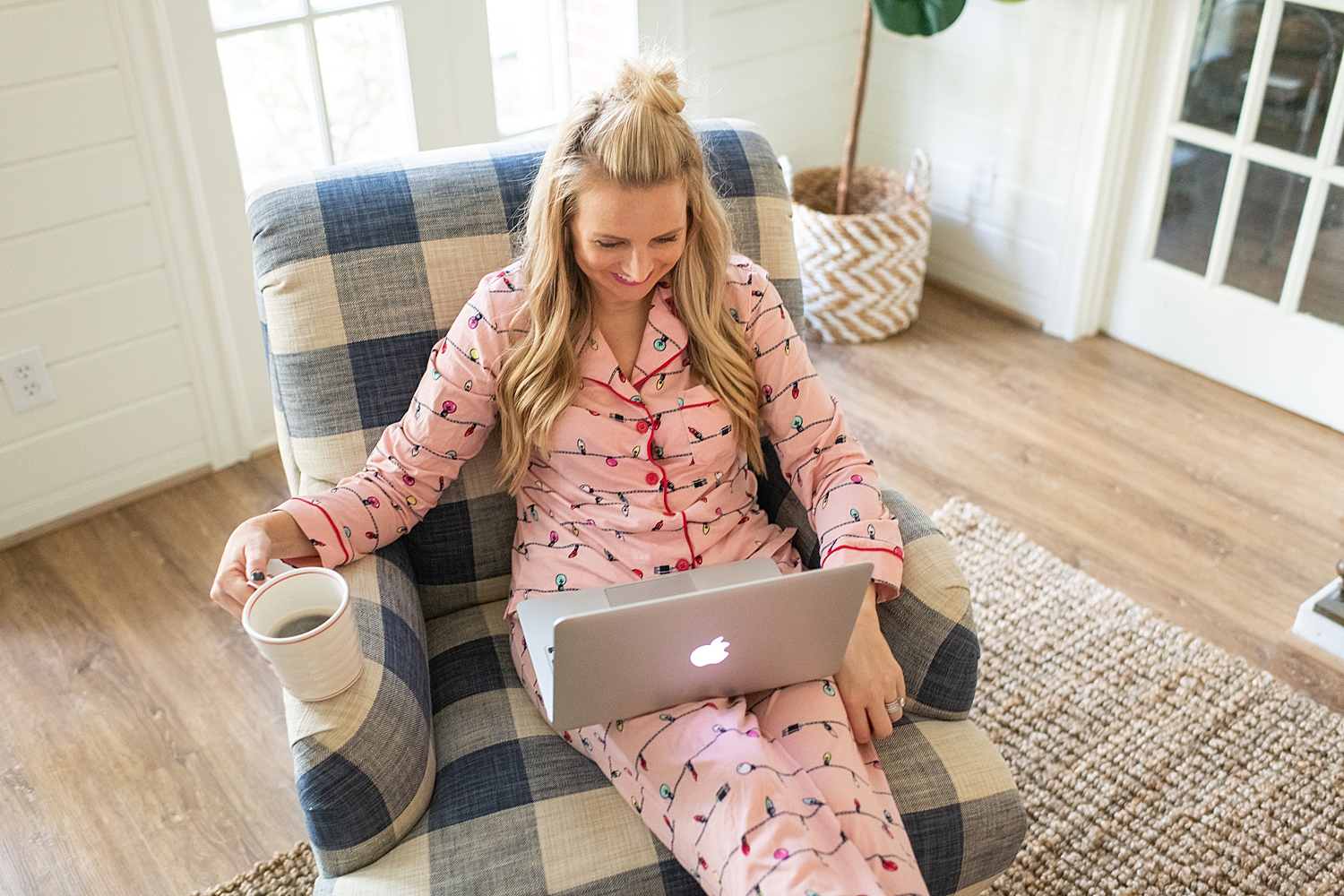 The Ultimate Cyber Monday Shopping Deals featured by top Houston life and style blogger, Fancy Ashley: picture of a blonde woman wearing Holidays PJs, sat on an armchair and looking at her Apple laptop