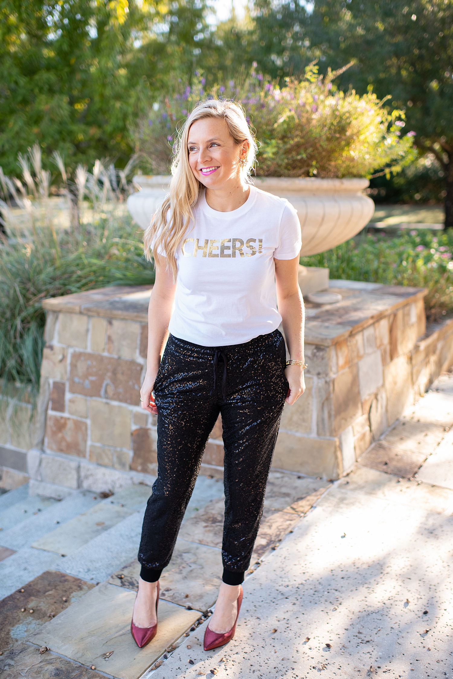Gibson x Glam Collection Outfits featured by top Houston fashion blog, Fancy Ashley: a blonde woman walking wearing black sequin joggers, cheers top and red heels