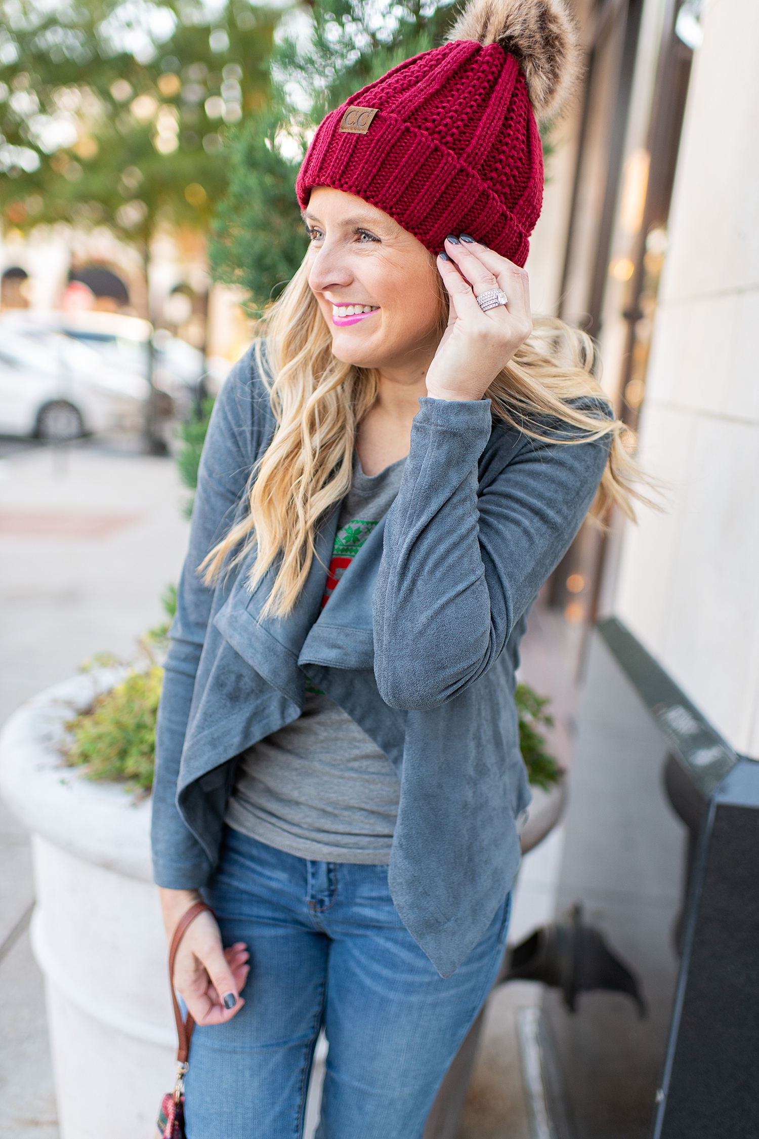 Fancy Ashley x Social Threads collection featured by top Houston fashion blogger, Fancy Ashley: image of a woman wearing a Social Threads faux suede jacket, Social Threads festive graphic tee, Social Threads skinny jeans, Social Threads Pom Paom Hat and Golden Goose sneakers
