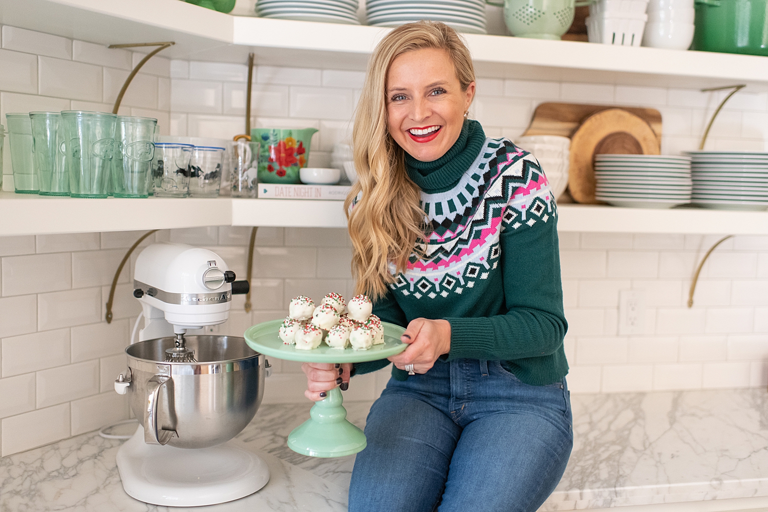 Gluten Free Sugar Cookie Truffles featured by top Houston lifestyle blog, Fancy Ashley: blonde woman sat on countertop holding a plate of gluten free sugar cookie truffles