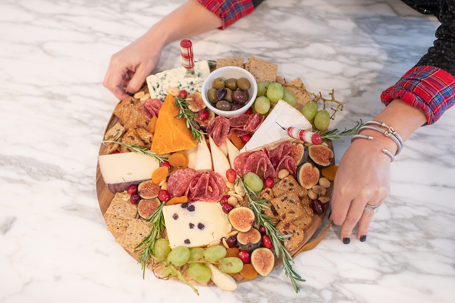 Top Houston life and style blogger, Fancy Ashley, features her tips to prepare the perfect Charcuterie Tray for the Holidays: image of a woman holding a festive charcuterie tray