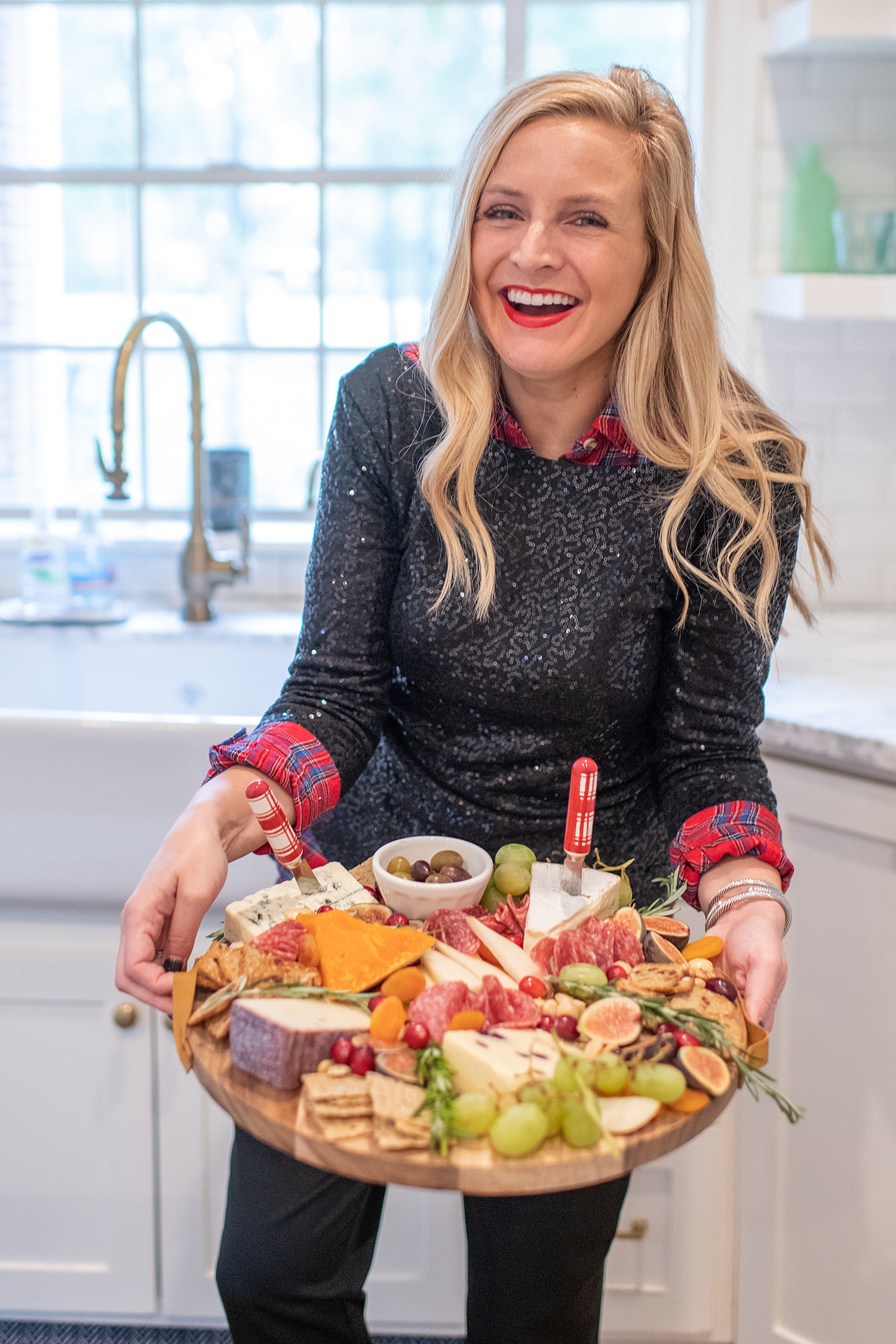 Top Houston life and style blogger, Fancy Ashley, features her tips to prepare the perfect Charcuterie Tray for the Holidays: image of a woman holding a festive charcuterie tray