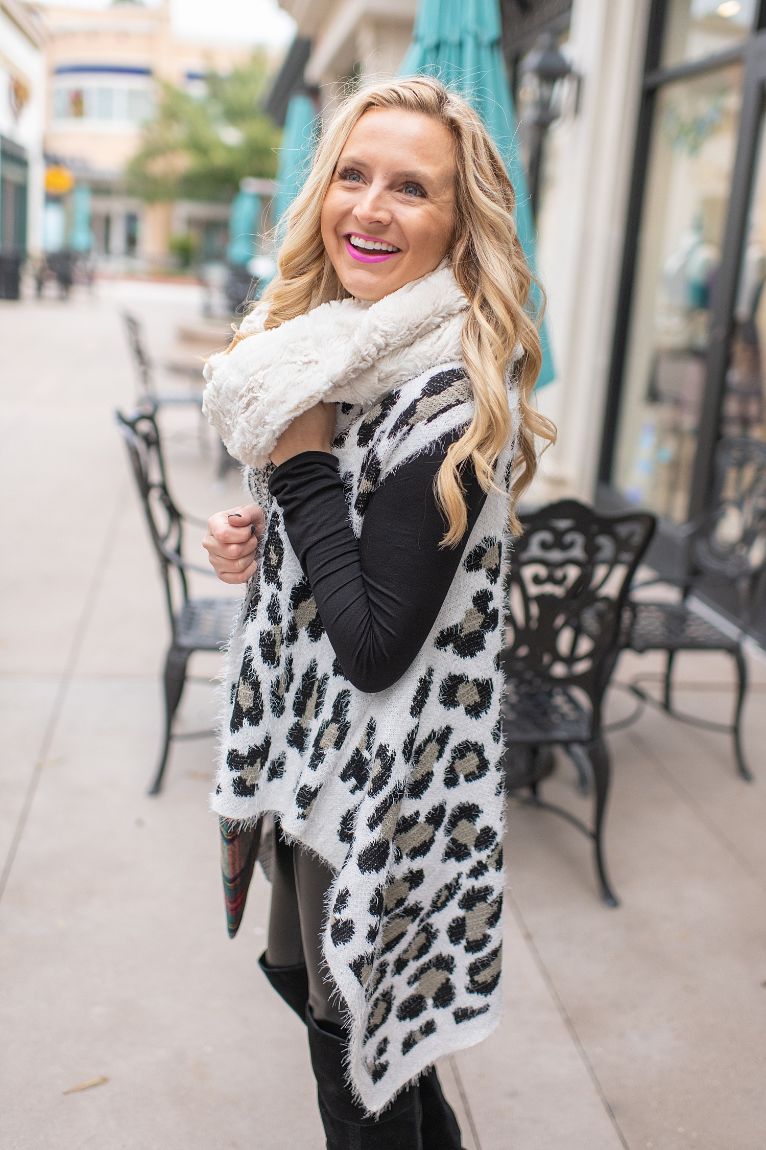 Fancy Ashley x Social Threads collection featured by top Houston fashion blogger, Fancy Ashley: image of a woman wearing a Social Threads Leopard vest, Social Threads faux leather leggings, Social Threads plaid clutch, Social Threads white infinity scarf and Vince Camuto Over the Knees Boots