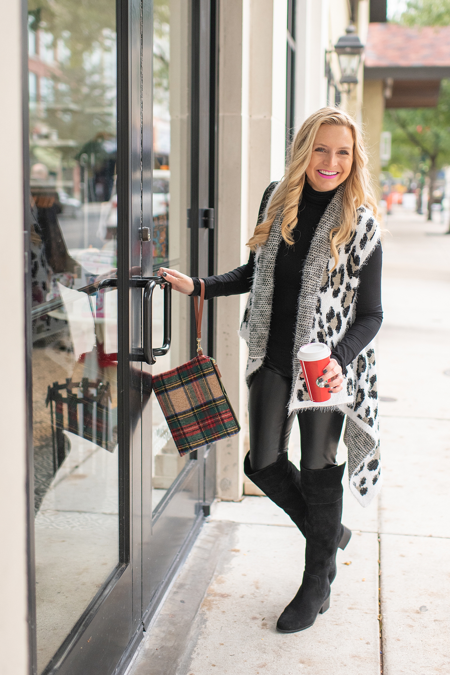 Fancy Ashley x Social Threads collection featured by top Houston fashion blogger, Fancy Ashley: image of a woman wearing a Social Threads Leopard vest, Social Threads faux leather leggings, Social Threads plaid clutch and Vince Camuto Over the Knees Boots