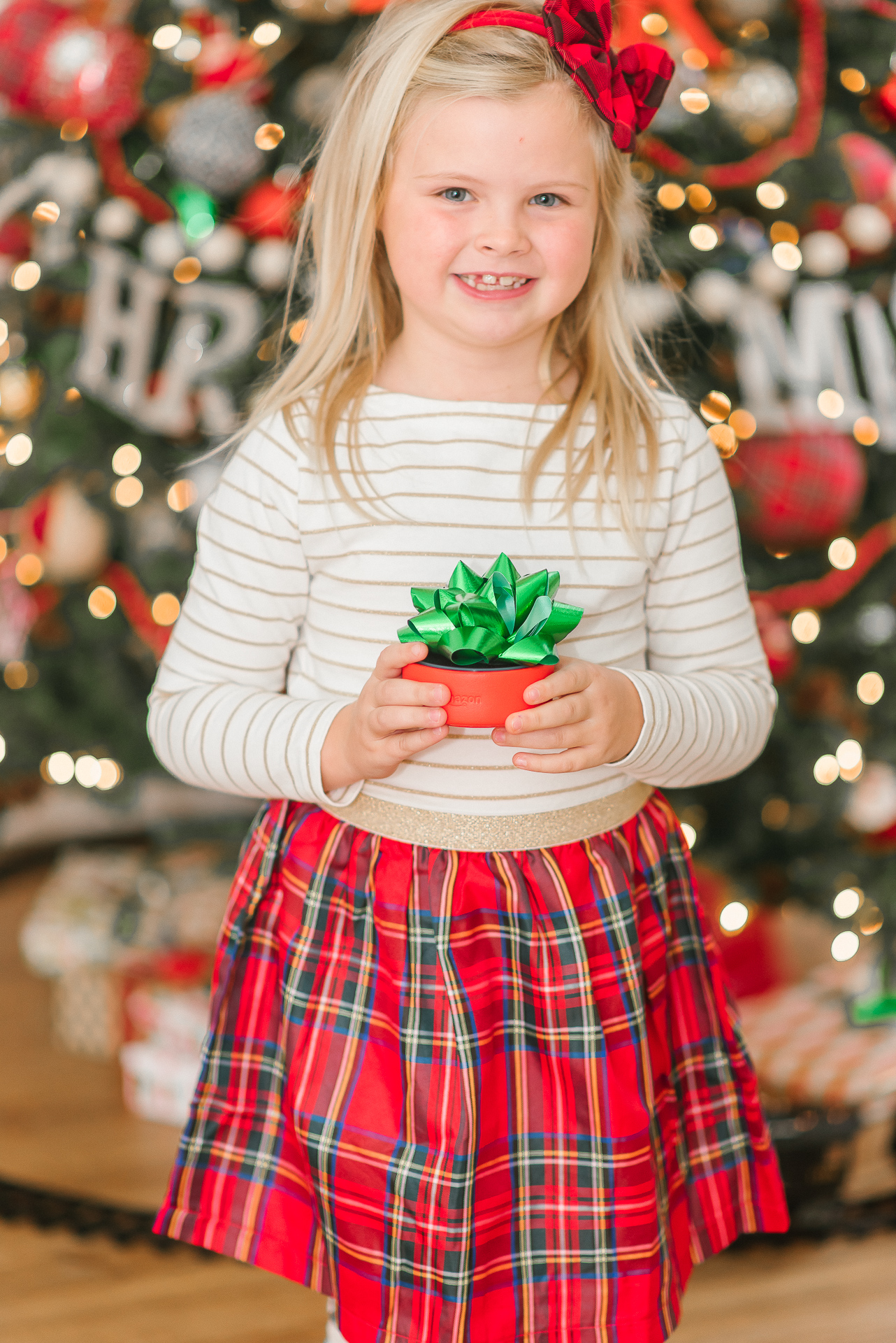 Echo Dot Kids Edition review featured by top Houston lifestyle blogger, Fancy Ashley: image of a girl holding a wrapped Amazon Echo Kids Edition