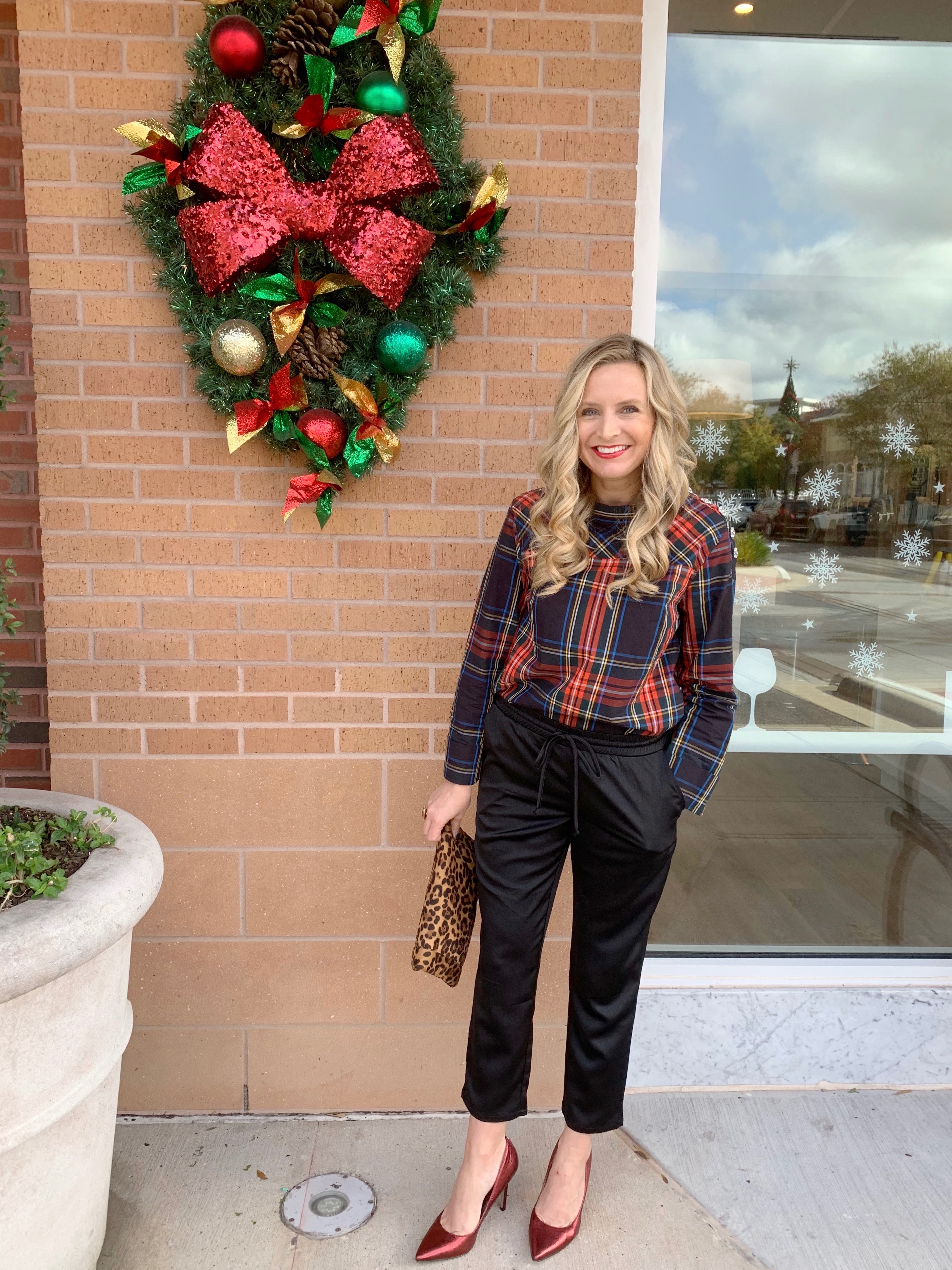Top Houston fashion blogger, Fancy Ashley, features 7 Holiday Outfits perfect for the season: image of a woman wearing J.Crew plaid shirt, black jogger pants, Kate Spade earrings, leopard clutch and sam Edelman leopard pumps all available at Nordstrom