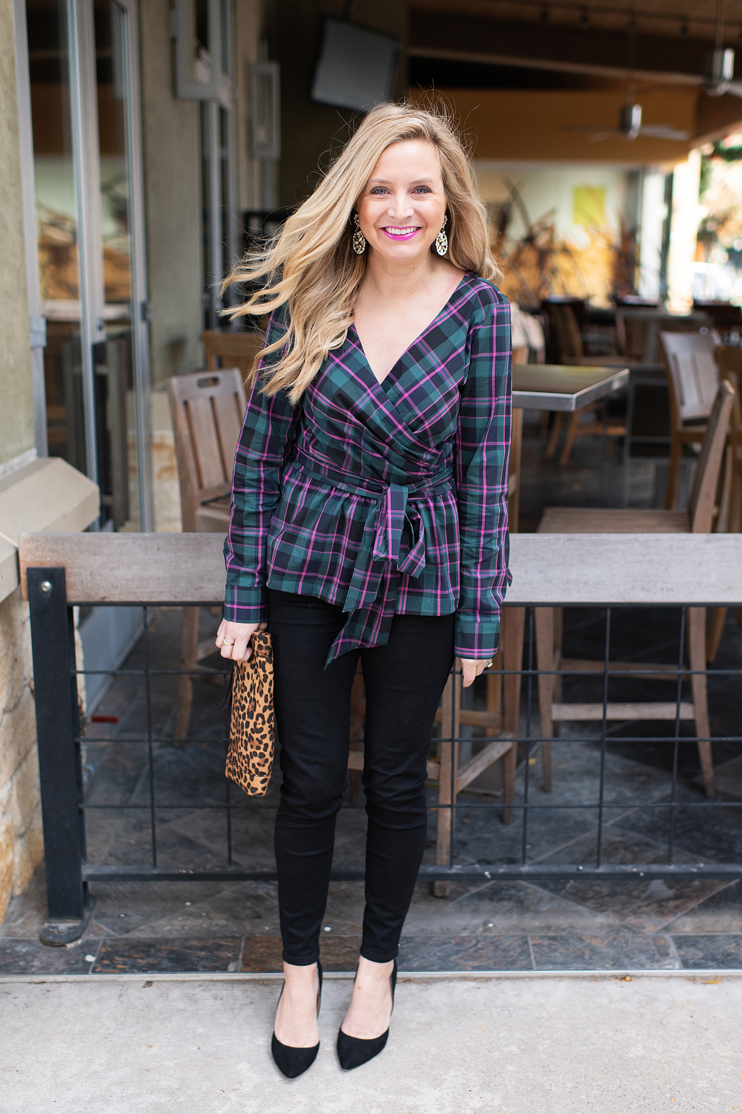Top Houston fashion blogger, Fancy Ashley, features 7 Holiday Outfits perfect for the season: image of a woman wearing Plaid wrap top, black ankle skinny jeans, Kate Spade earrings, leopard clutch all available at Nordstrom