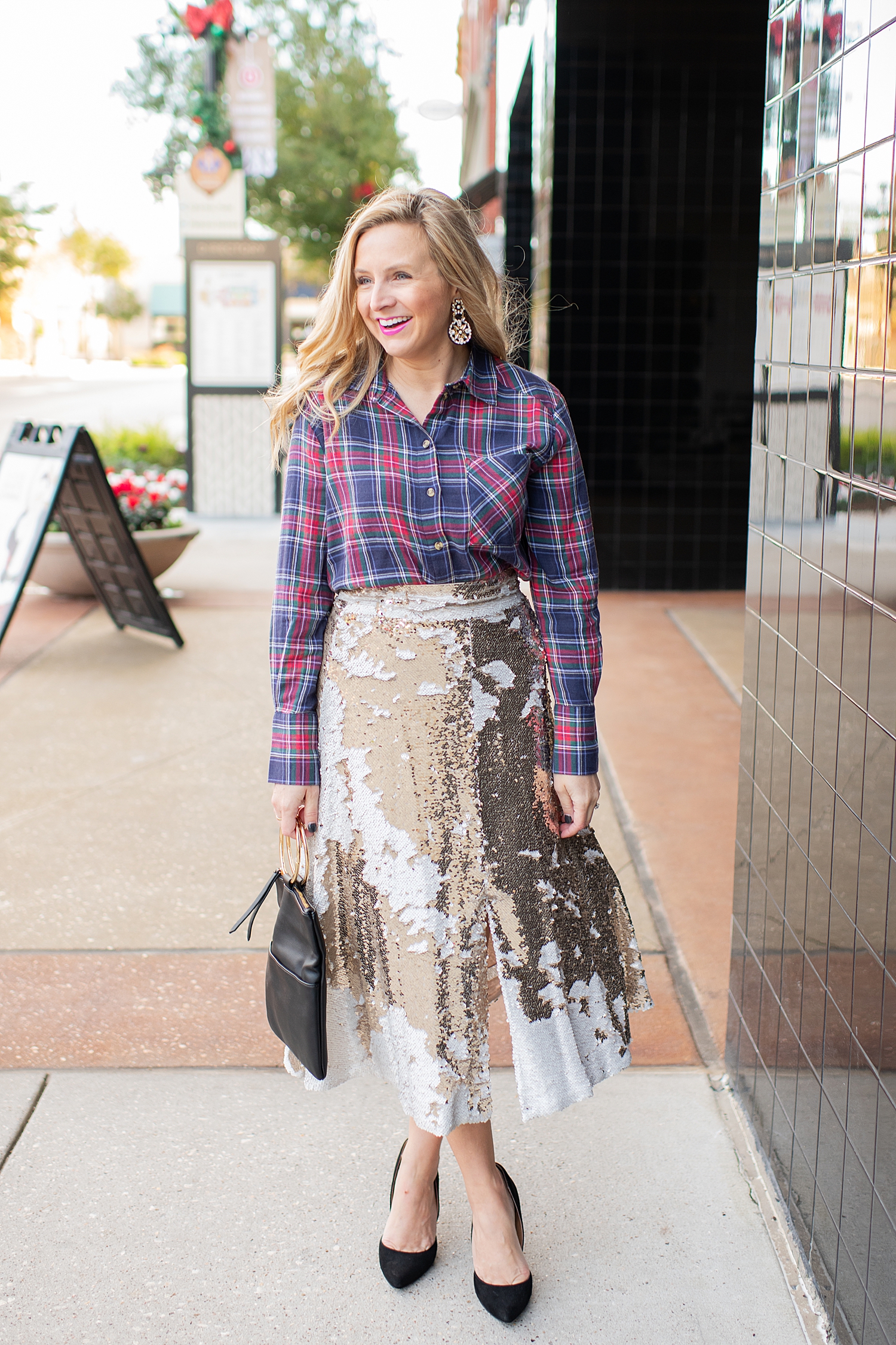 Top Houston fashion blogger, Fancy Ashley, features 7 Holiday Outfits perfect for the season: image of a woman wearing TOPSHOP plaid shirt, Eliza J sequin skirt, Kate Spade earrings, blck clutch all available at Nordstrom