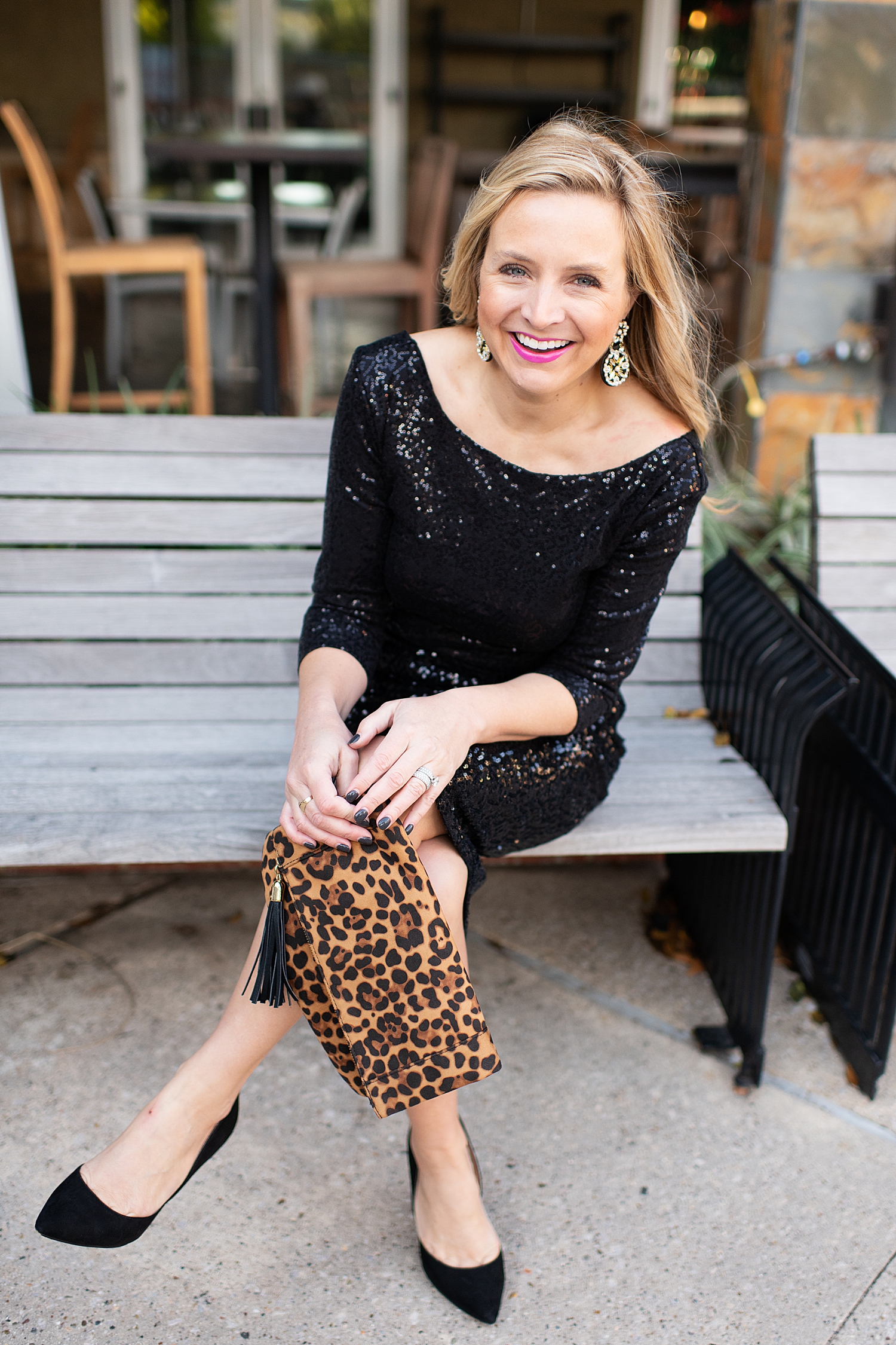 Top Houston fashion blogger, Fancy Ashley, features 7 Holiday Outfits perfect for the season: image of a woman wearing Black sequin top, sequin pencil skirt, Kate Spade earrings, leopard clutch all available at Nordstrom