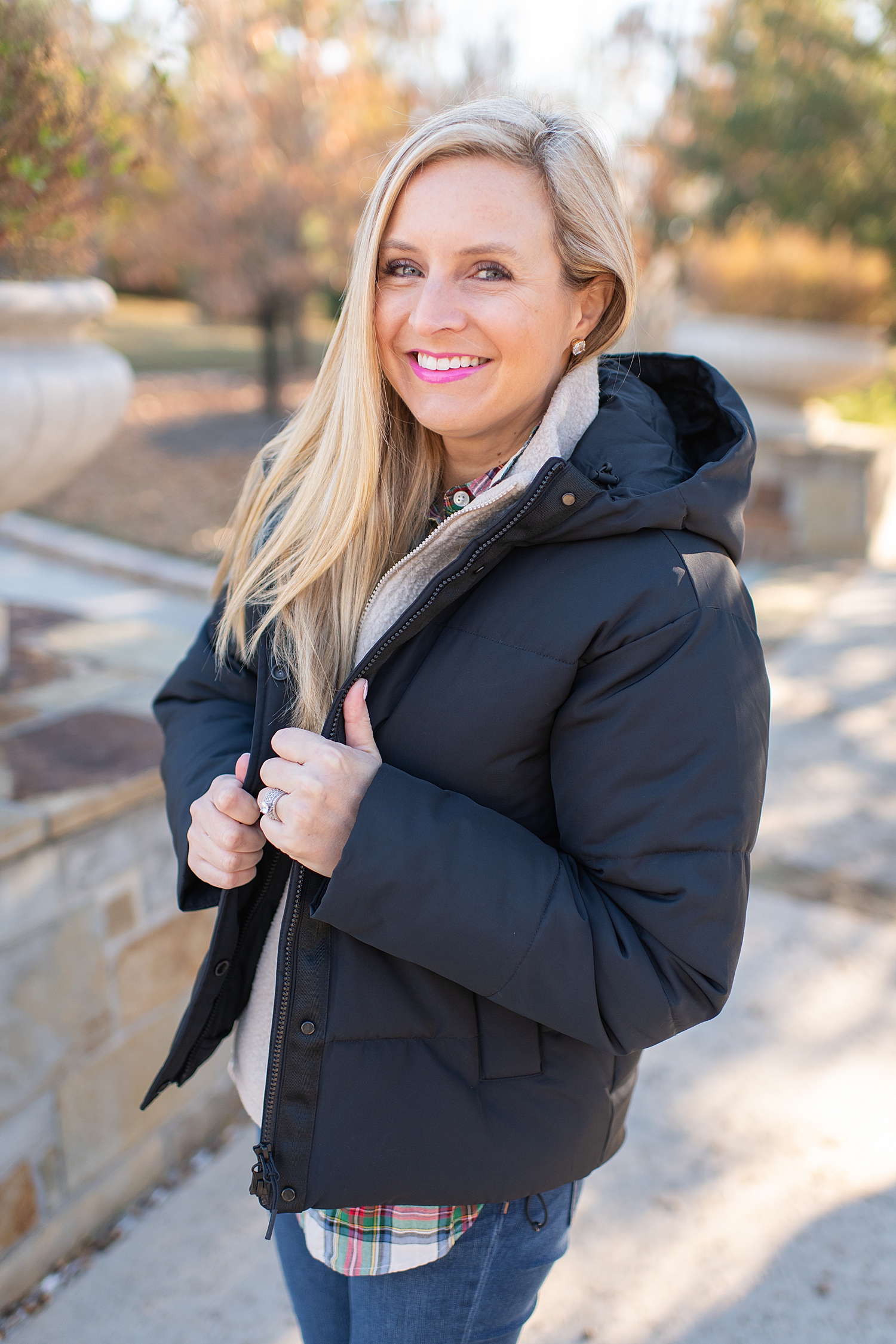 The Best Cozy Gift Ideas featured by top Houston fashion blogger, Fancy Ashley: picture of a blonde woman wearing a black Everyone puffer jacket, Everlane zip fleece, J.Crew tartan shirt, J.Crew skinny jeans and Golden Goose sneakers
