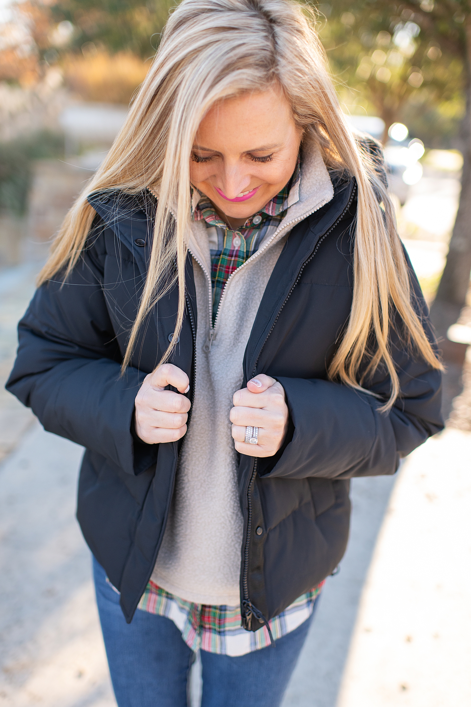 The Best Cozy Gift Ideas featured by top Houston fashion blogger, Fancy Ashley: picture of a blonde woman wearing a black Everyone puffer jacket, Everlane zip fleece, J.Crew tartan shirt, J.Crew skinny jeans and Golden Goose sneakers
