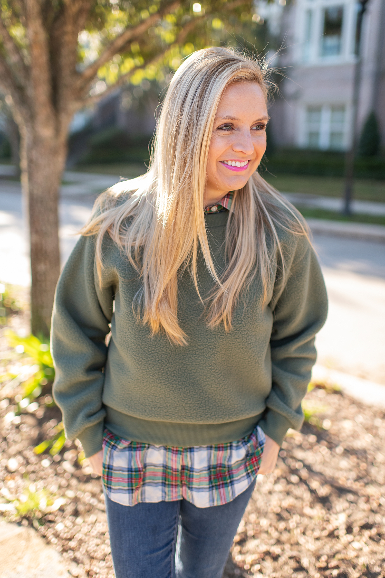 The Best Cozy Gift Ideas featured by top Houston fashion blogger, Fancy Ashley: picture of a blonde woman wearing a green Everlane fleece sweatshirt, J.Crew tartan shirt, J.Crew skinny jeans and Golden Goose sneakers