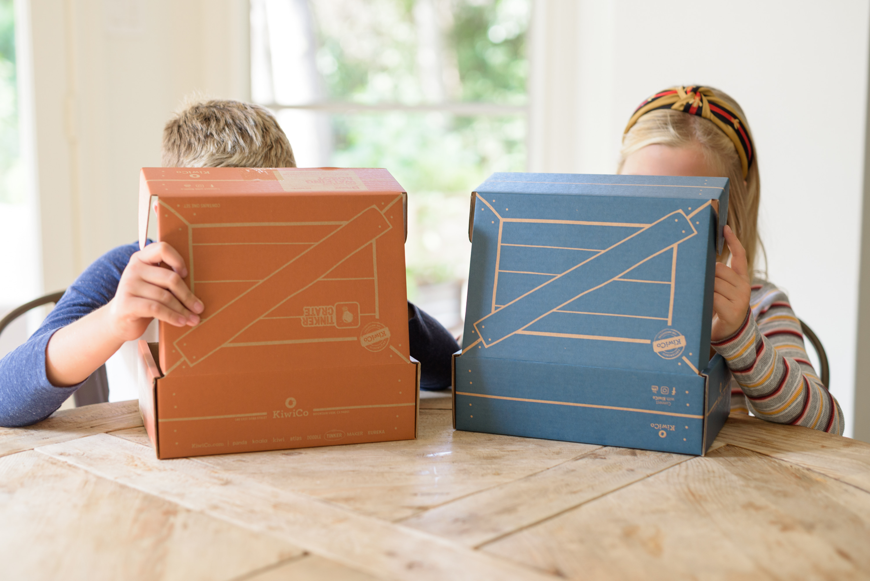 Kiwico Reviews by popular Houston lifestyle blog, Fancy Ashley: image of two kids looking at Kiwico boxes. 