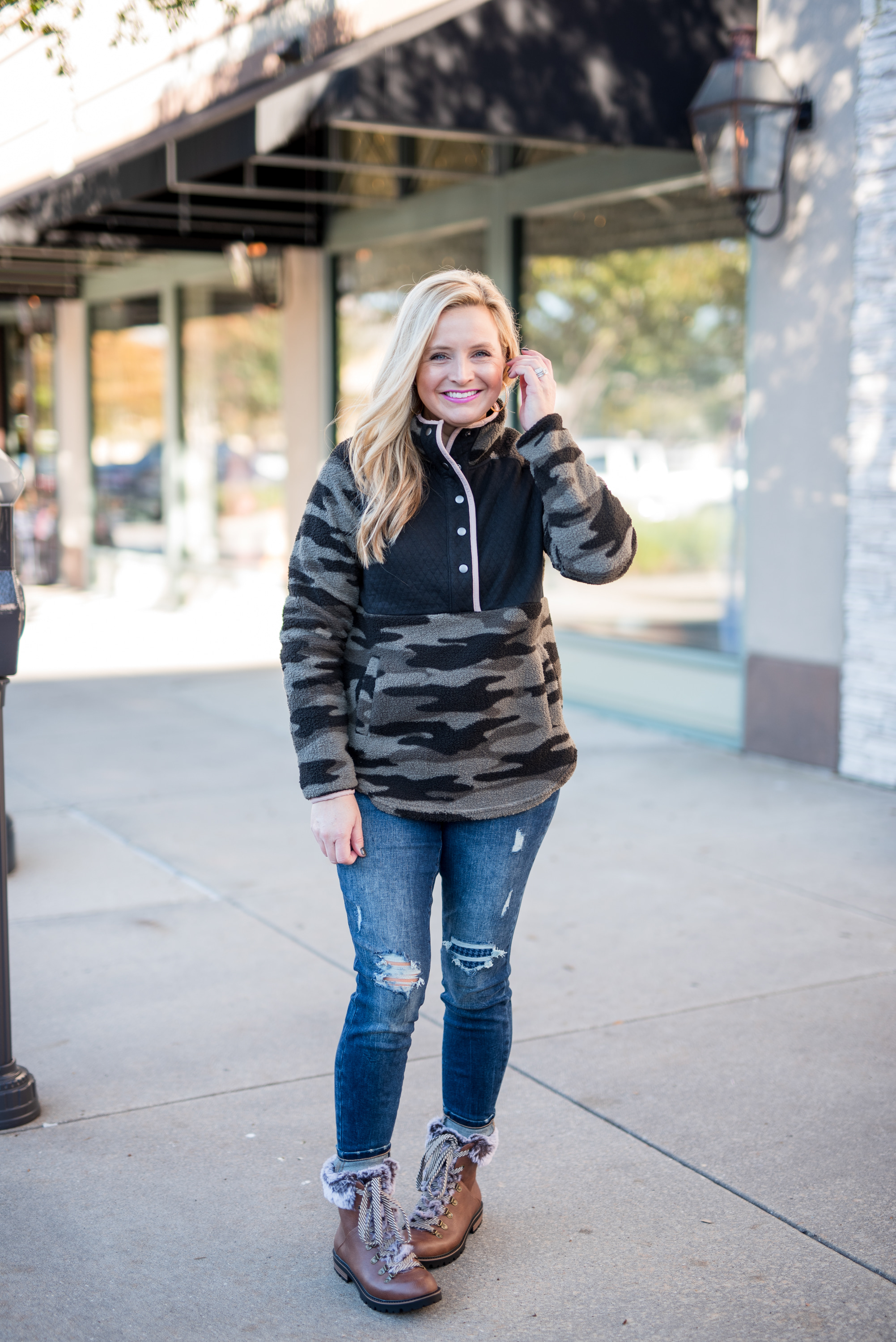 Maurice's Clothing by popular Houston fashion blog, Fancy Ashley: image of a woman wearing a Maurice's camo fleece pullover, distressed denim, and brown fur trimmed combat boots. 