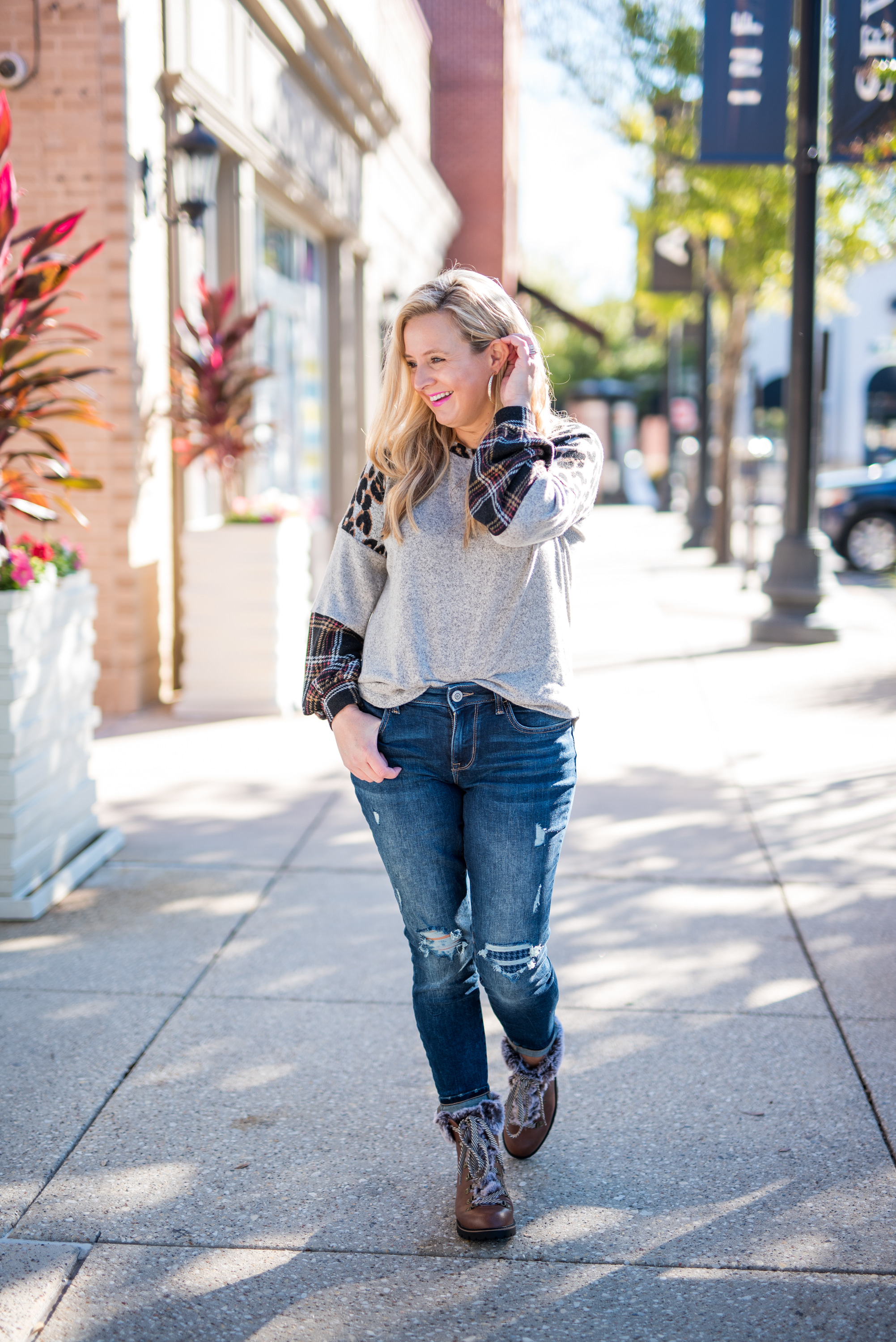 Maurice's Clothing by popular Houston fashion blog, Fancy Ashley: image of a woman wearing a Maurice's 24/7 Leopard Plaid Colorblock Blouson Sleeve Baseball Tee, distressed denim, and brown fur trimmed combat boots. 