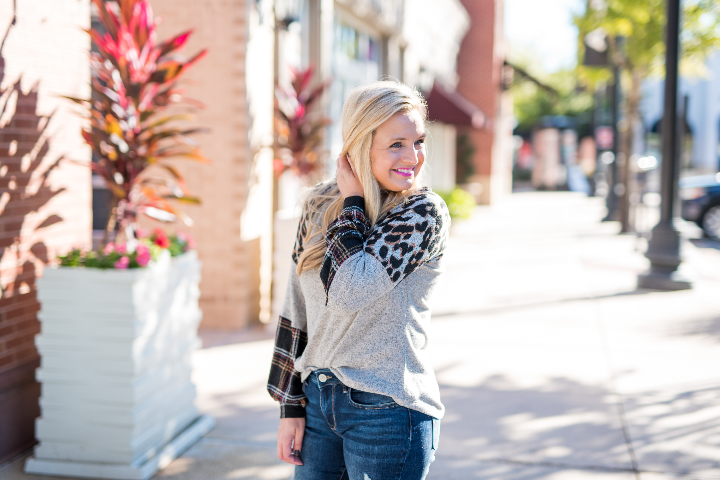 Maurice's Clothing by popular Houston fashion blog, Fancy Ashley: image of a woman wearing a Maurice's 24/7 Leopard Plaid Colorblock Blouson Sleeve Baseball Tee, distressed denim, and brown fur trimmed combat boots. 