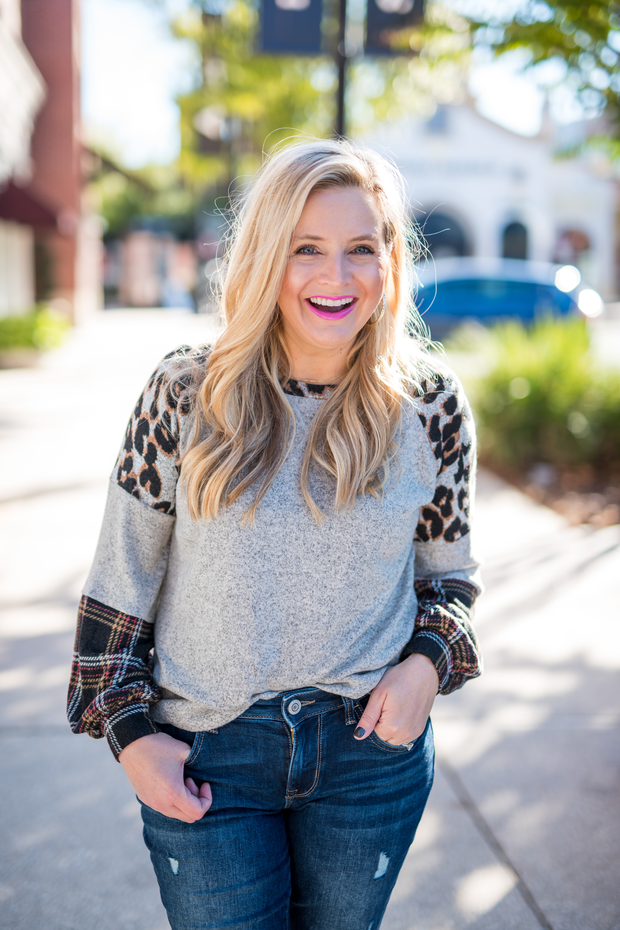 Maurice's Clothing by popular Houston fashion blog, Fancy Ashley: image of a woman wearing a Maurice's 24/7 Leopard Plaid Colorblock Blouson Sleeve Baseball Tee, distressed denim, and brown fur trimmed combat boots. 