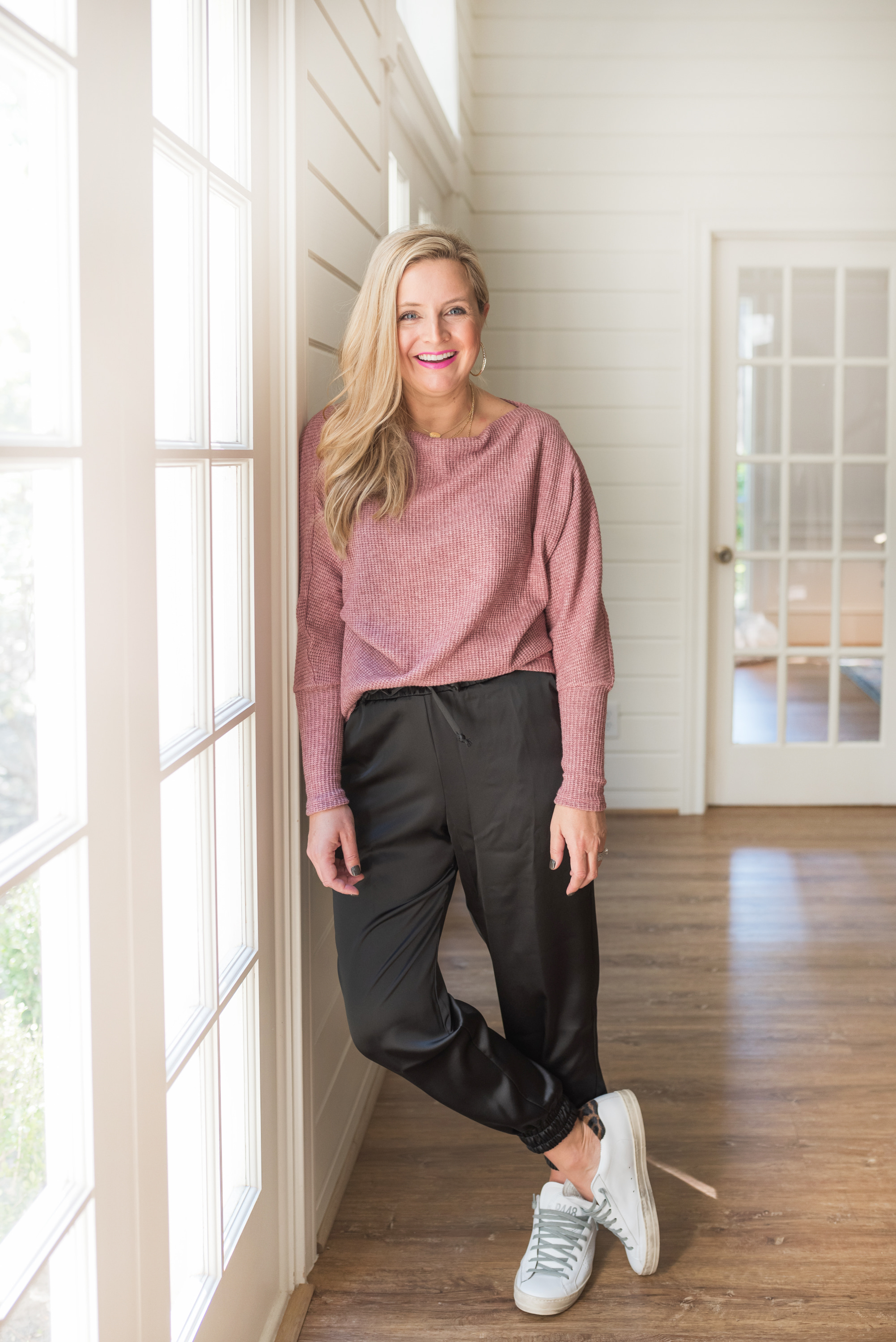 November Outfits by popular Houston fashion blog, Fancy Ashley: image of a woman wearing a pink thermal top, black satin joggers, and sneakers. 