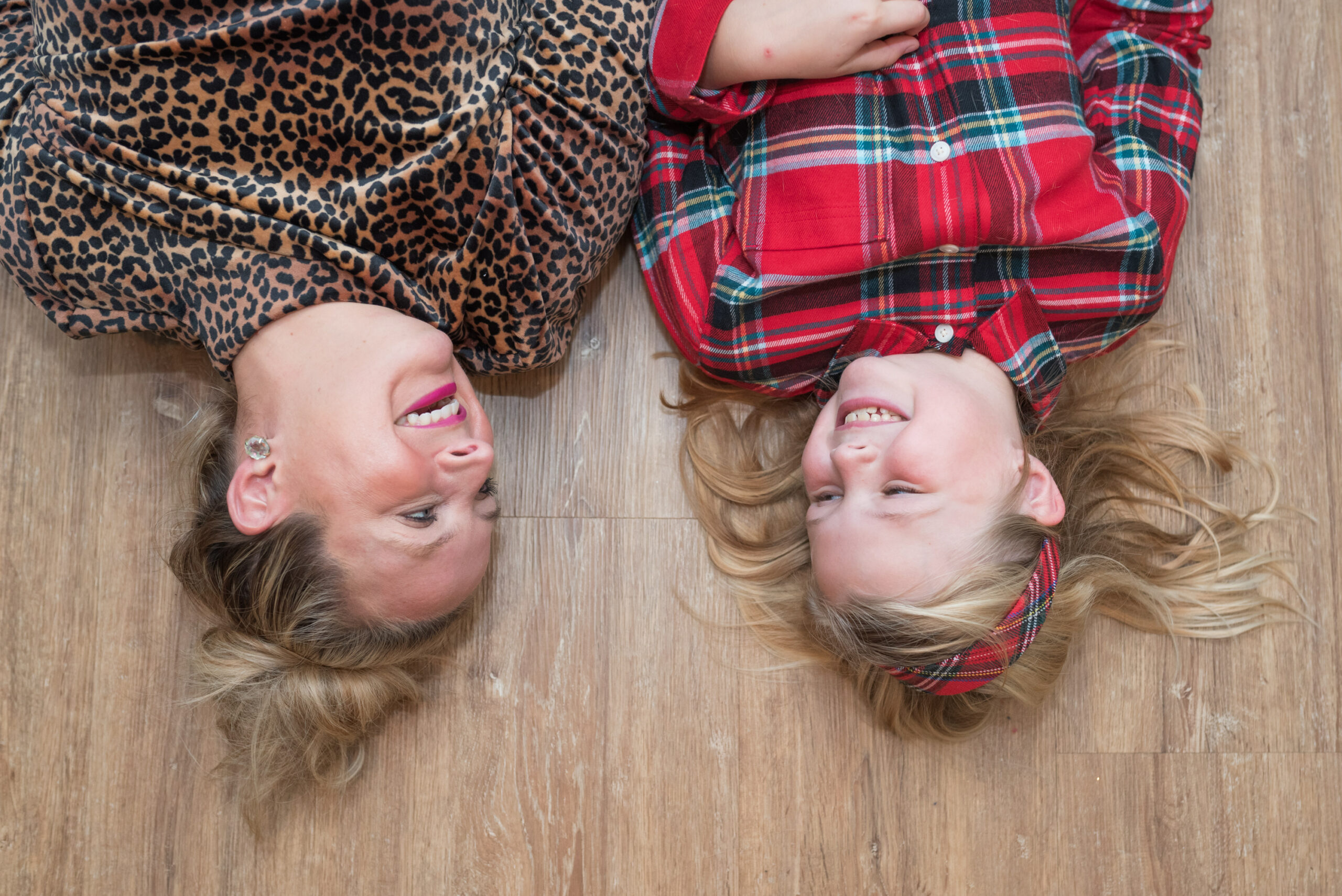 Family Christmas Pajamas by popular Houston fashion blog, Fancy Ashley: image of a mom and her daughter laying on the floor and wearing Land's End leopard print and red plaid pajamas. 