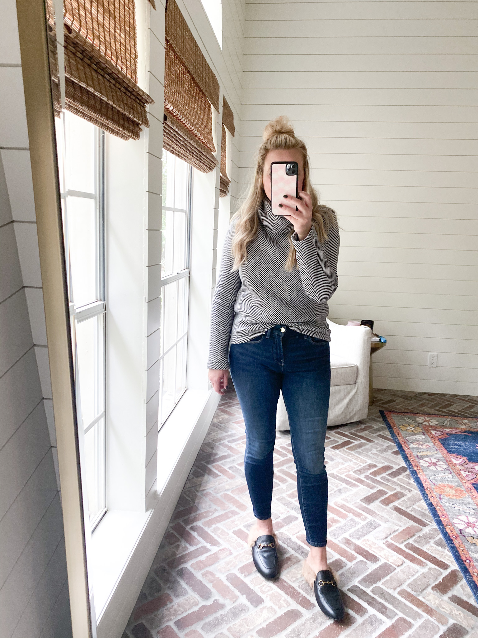 Cute Fall Outfits by popular Houston fashion blog, Fancy Ashley: image of a woman wearing a black and white pullover, jeans, and a faux fur lined slide black mules. 