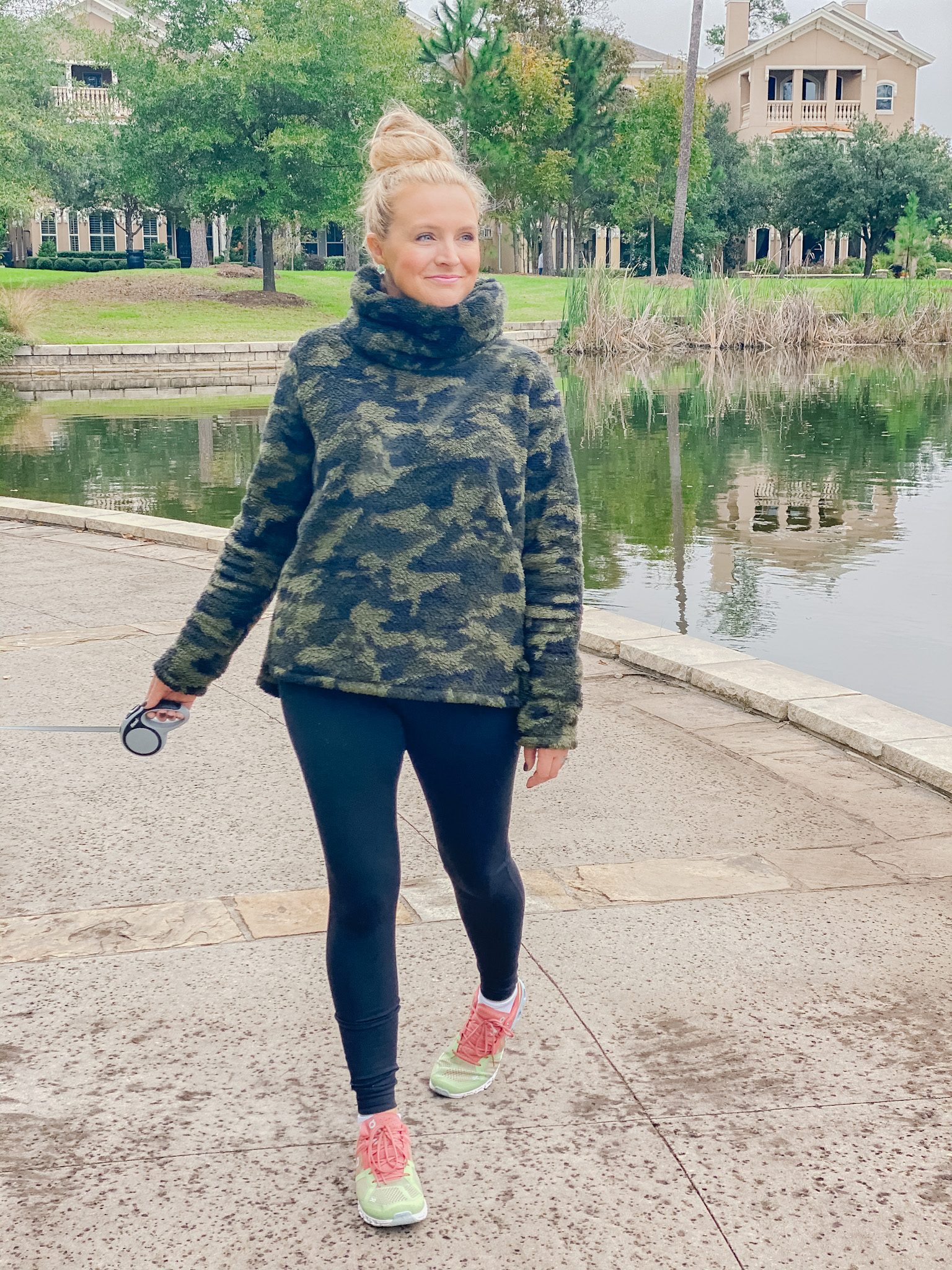 On Cloud Running Shoes by popular Houston fashion blog, Fancy Ashley: image of a woman walking her dog and wearing Shoes Cloudflow Running Shoes, Zella leggings, Zella camo fleece pullover, and Quay Australia sunglasses. 