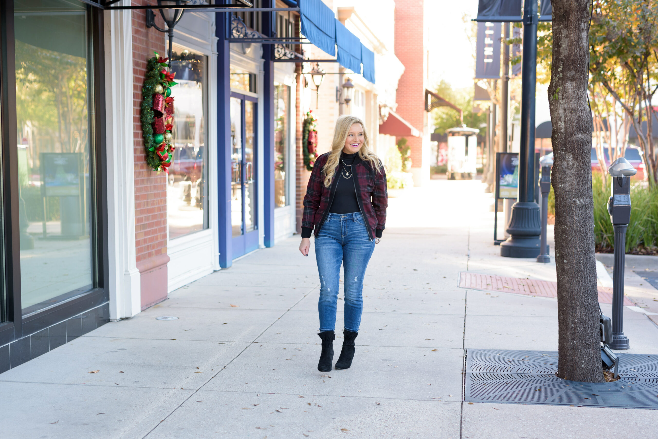 Winter Outfits by popular Houston fashion blog, Fancy Ashley: image of a woman standing outside and wearing Liverpool Los Angeles jeans, black turtleneck top, black ankle boots, and plaid jacket.