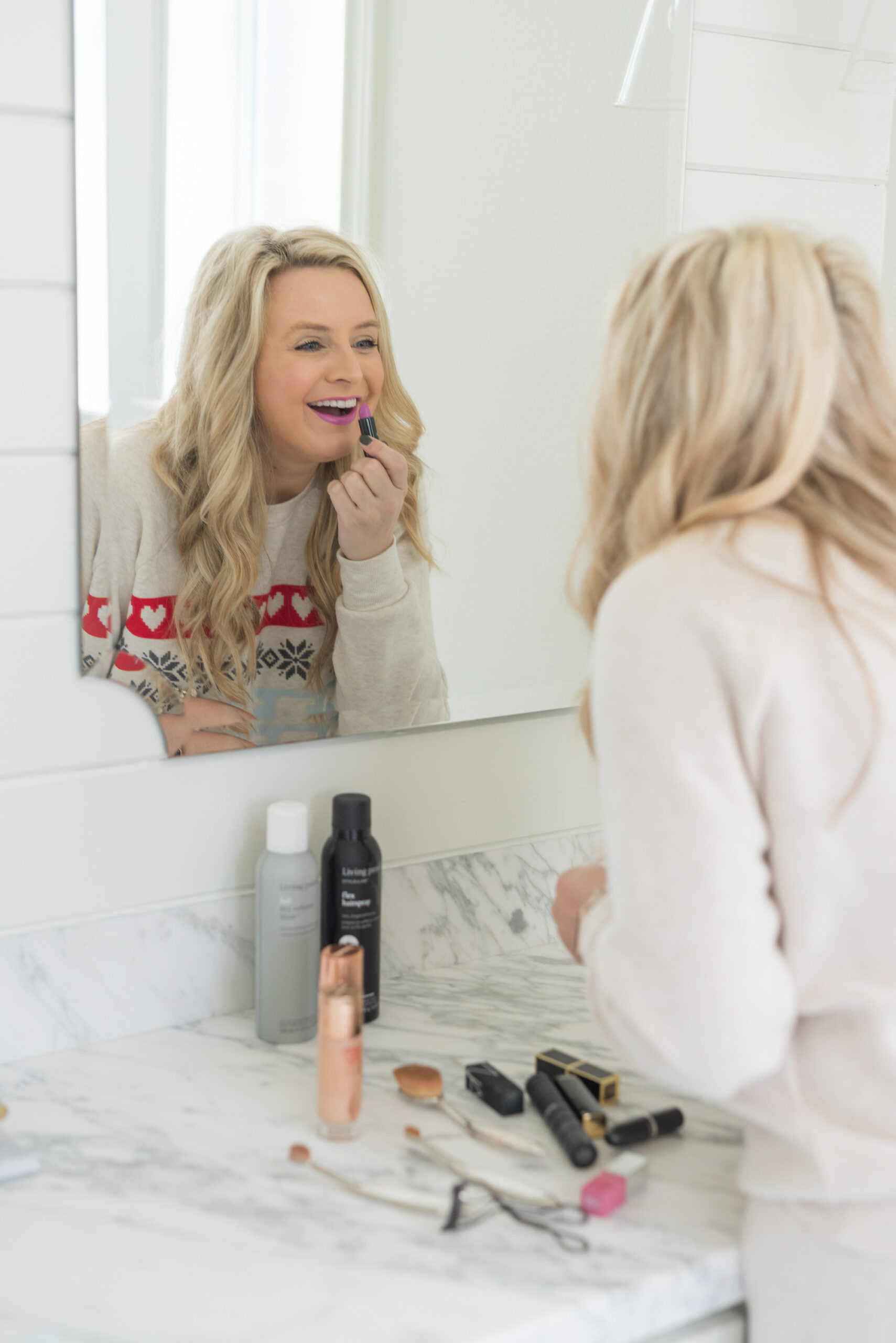 Nordstrom Beauty by popular Houston beauty blog, Fancy Ashley: image of a woman looking in her bathroom mirror and applying purple lipstick. 