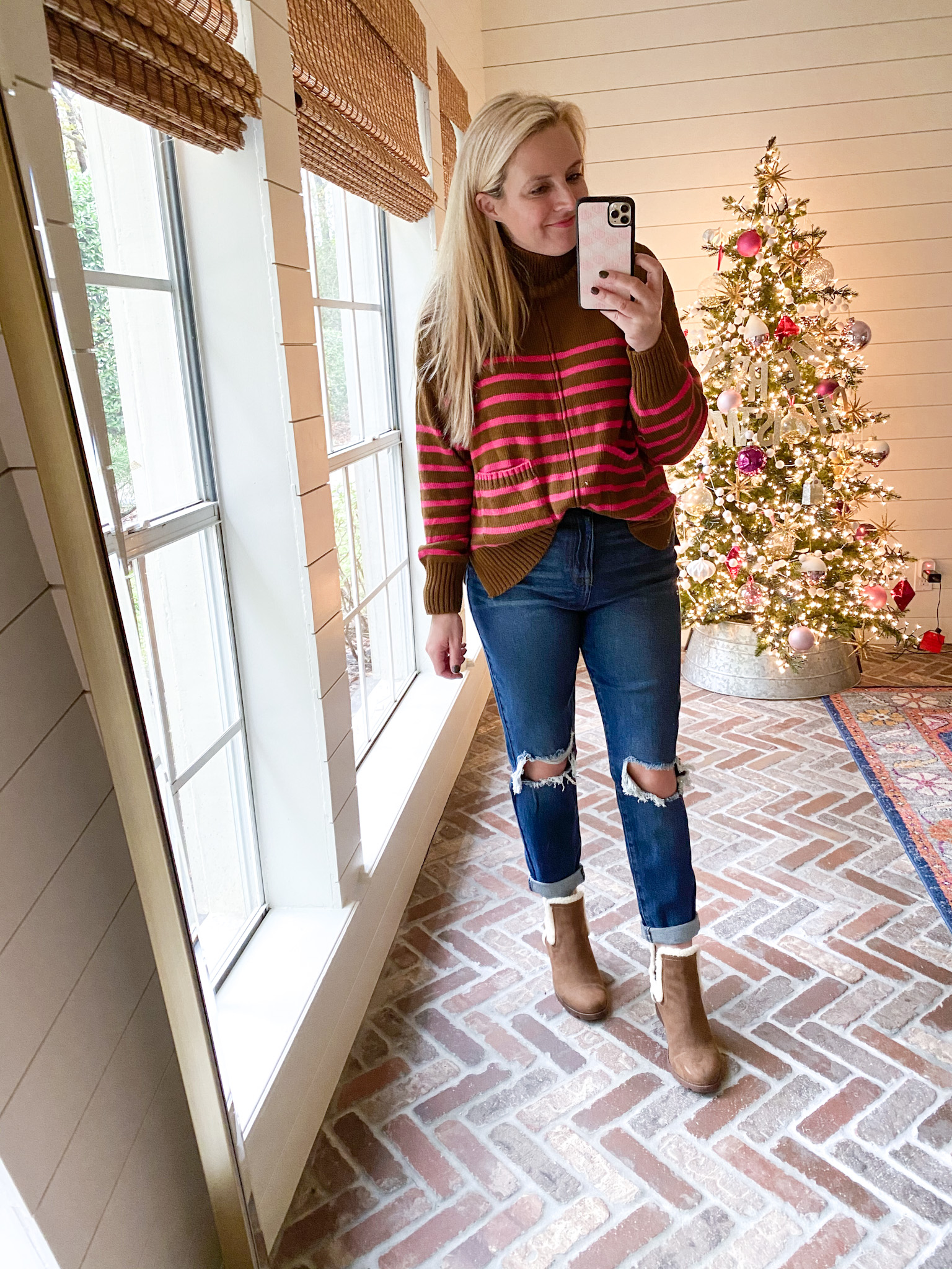 Walmart Fashion by popular Houston fashion blog, Fancy Ashley: image of a woman wearing a pink and brown stripe turtle neck sweater, distressed denim, and fur lined brown ankle boots. 