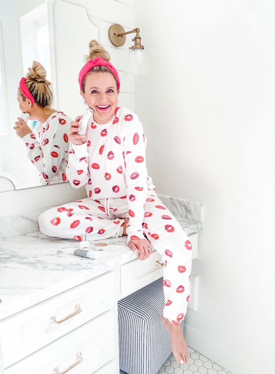 Like To Know It by popular Houston life and style blog, Fancy Ashely: image of a woman wearing a pink knot headband, lip print pullover, lip print jogger pants, and sitting on her bathroom counter. 