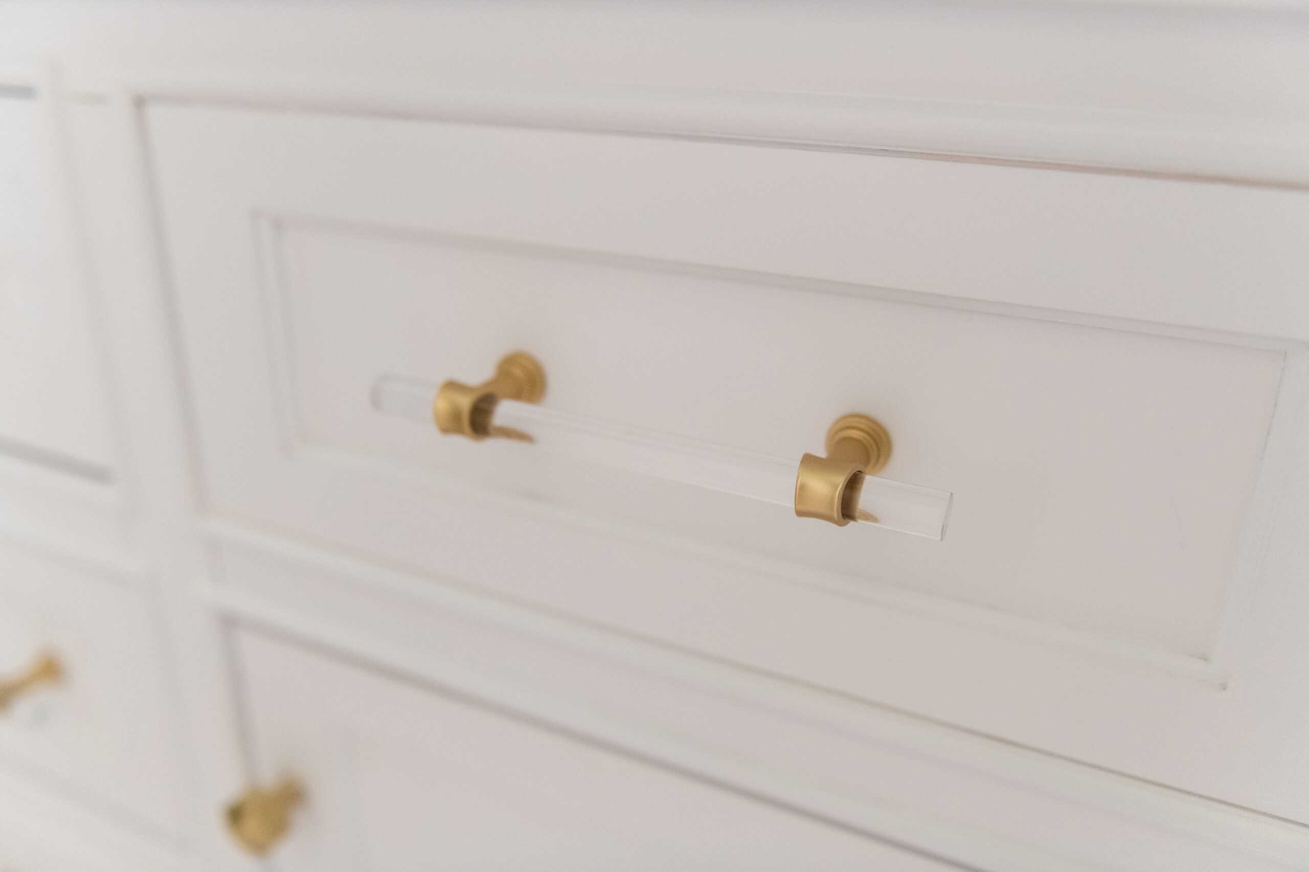 Girls Bathroom by popular Houston life and style blog, Fancy Ashley: image of a white vanity with gold and acrylic drawer pulls. 