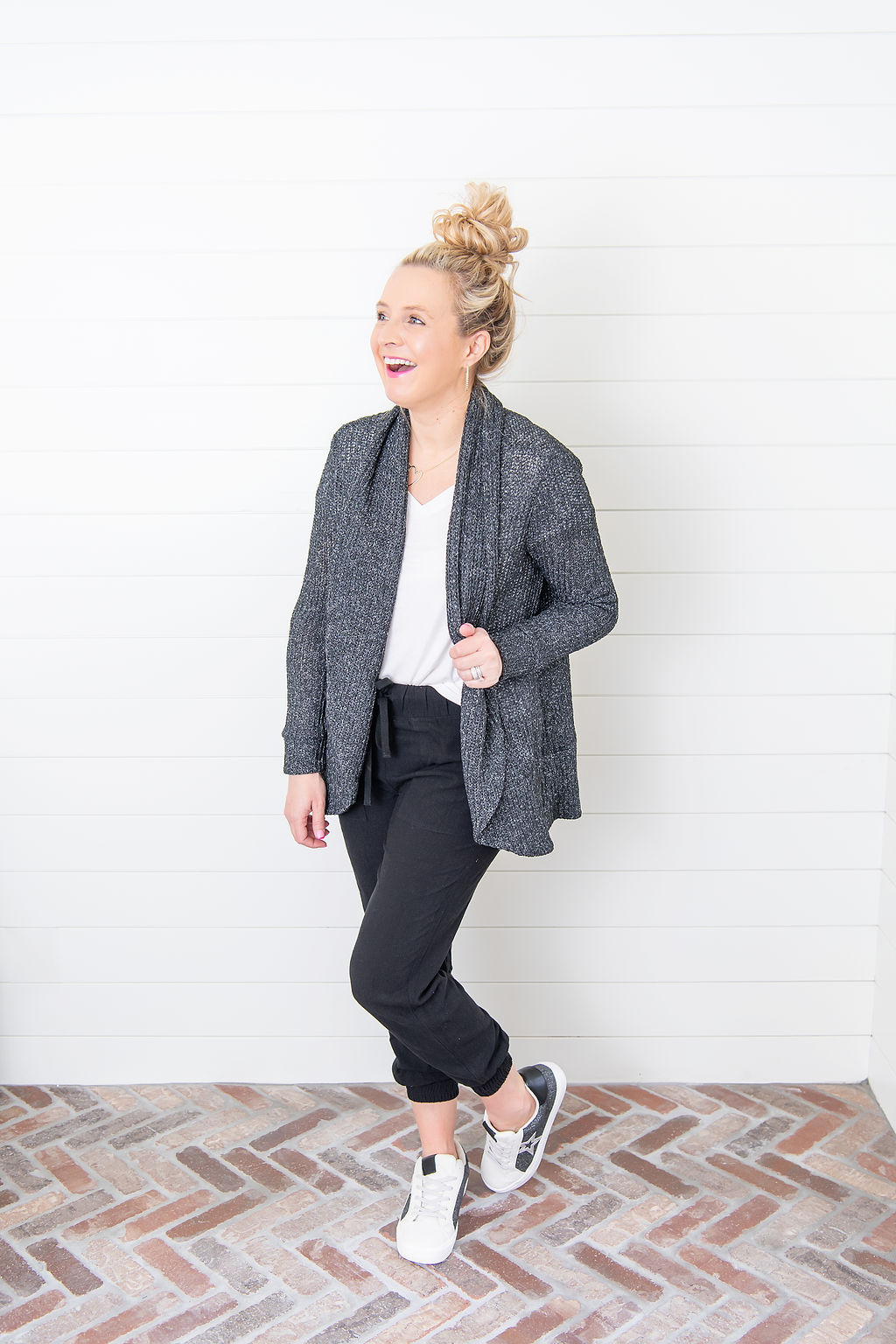International Women's Day with Gibson by popular Houston fashion blog, Fancy Ashley: image of a woman wearing a Gibson white v-neck shirt, black joggers, sneakers, and black drop sleeve sweater. 