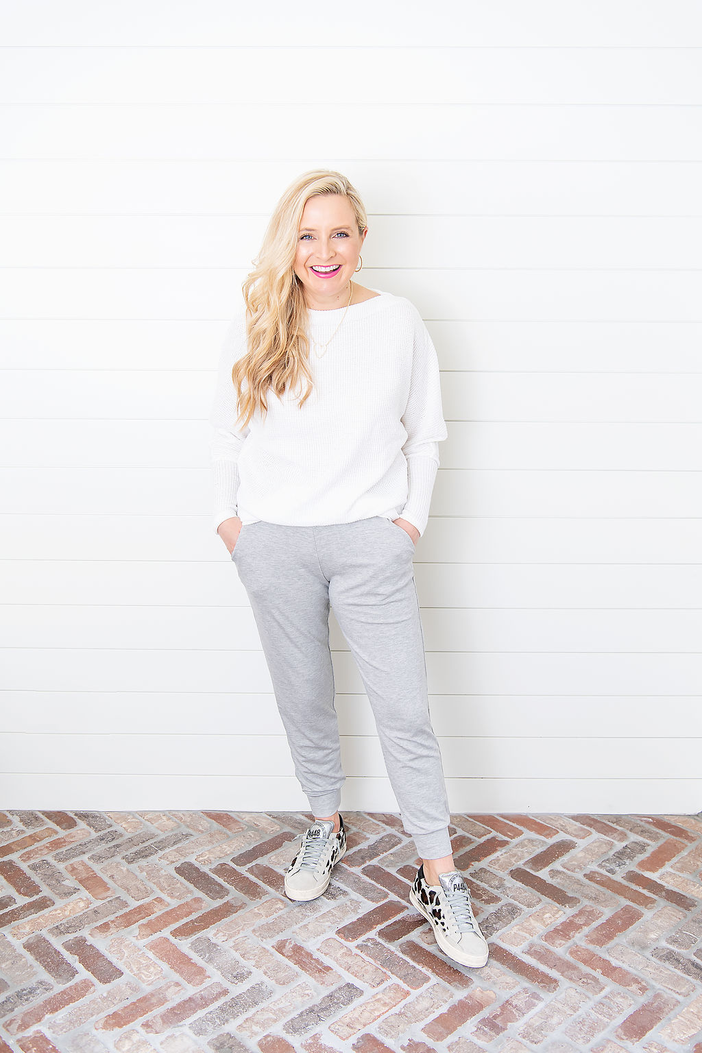 International Women's Day with Gibson by popular Houston fashion blog, Fancy Ashley: image of a woman wearing a Gibson Fancy Ashley sweater with a pair of grey joggers and animal print P448 sneakers.  