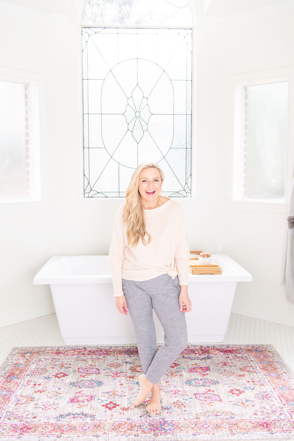 International Women's Day with Gibson by popular Houston fashion blog, Fancy Ashley: image of a woman wearing a Gibson sweater with a pair of grey knit joggers while standing in a bathroom in front of a white soaking tub. 
