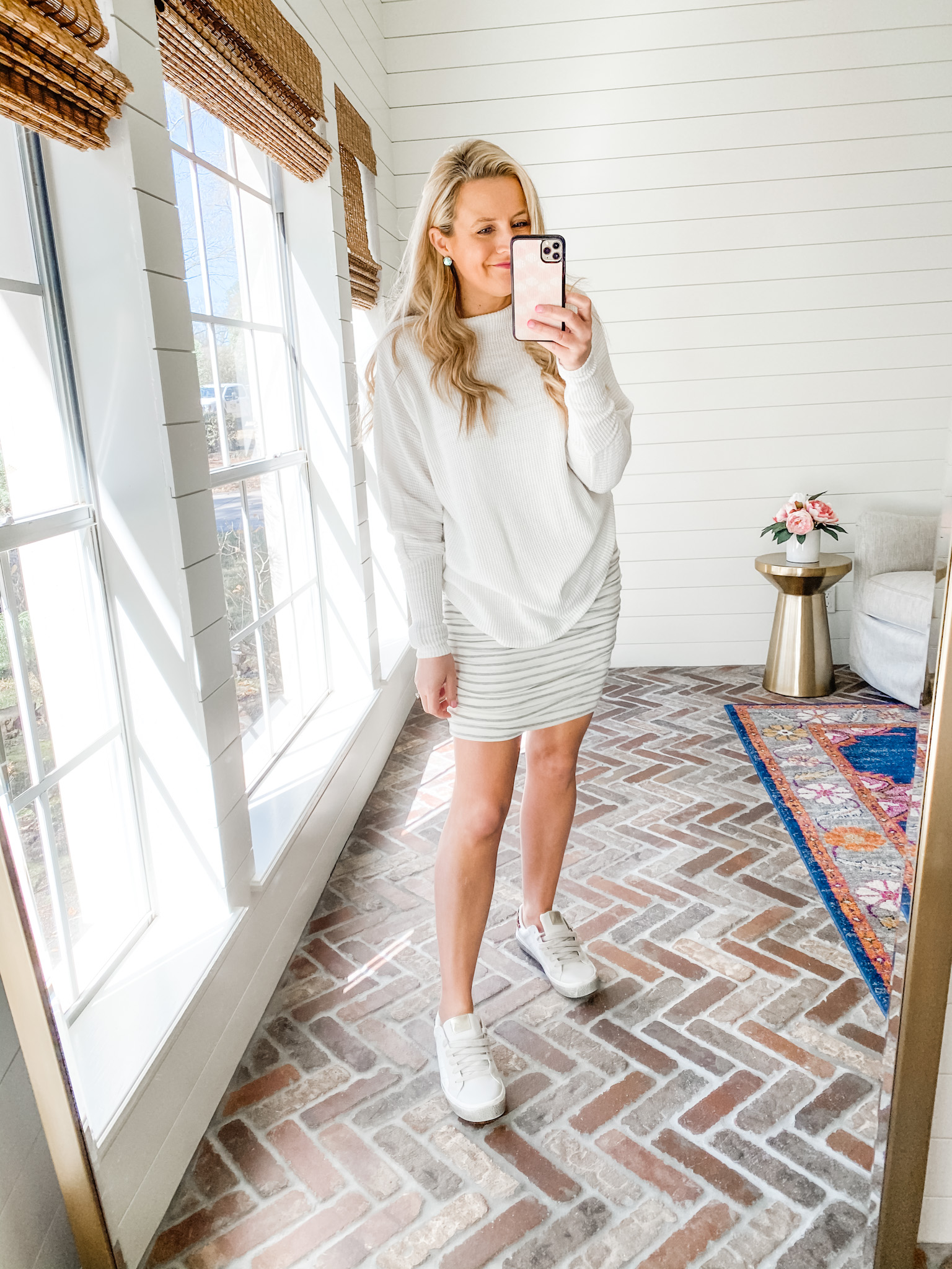 Fitting Room Finds by popular Houston fashion blog, Fancy Ashley: image of a woman wearing a Gibson white sweater with a black and white stripe skirt and white sneakers. 