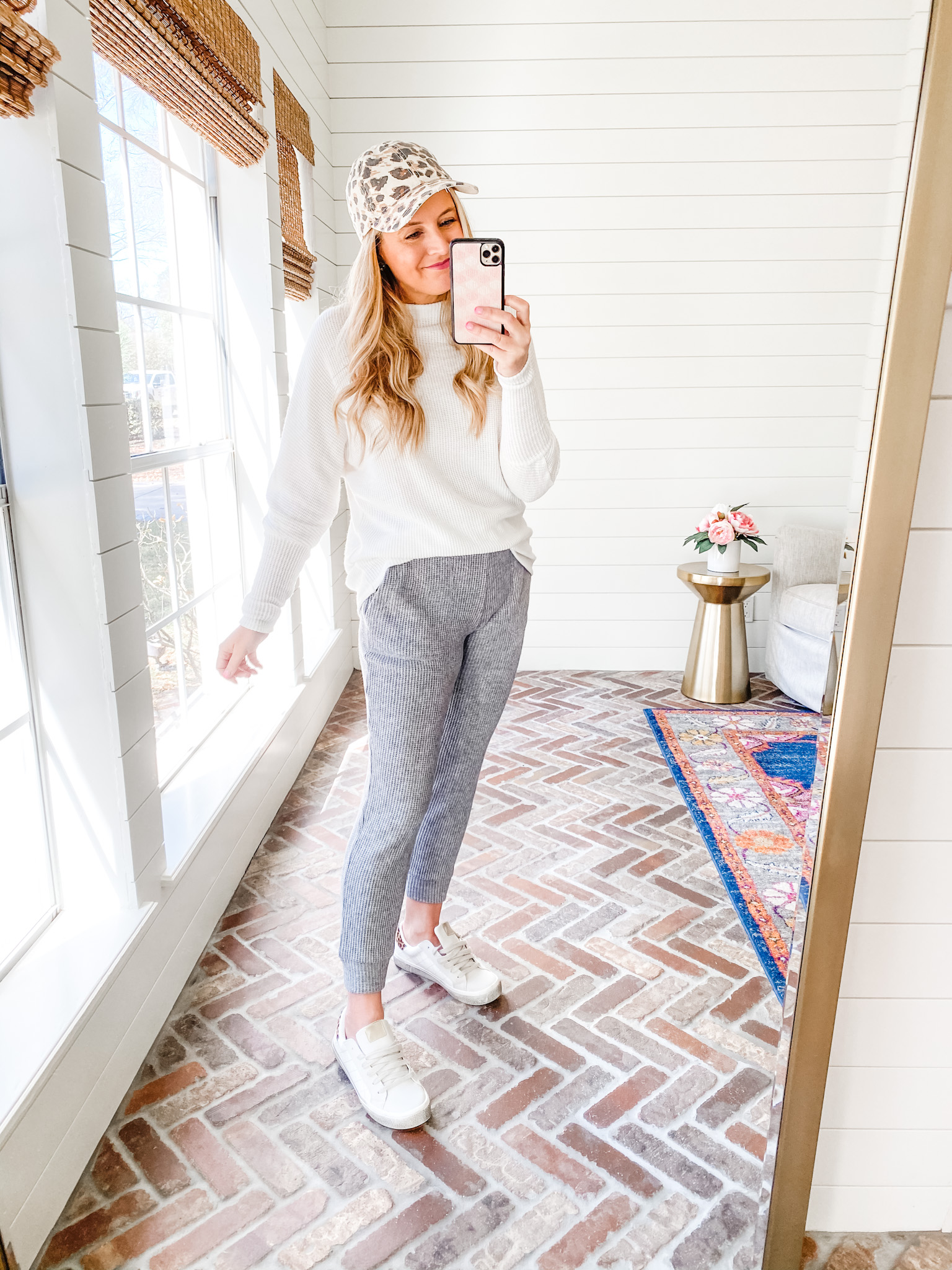 Fitting Room Finds by popular Houston fashion blog, Fancy Ashley: image of a woman wearing a Gibson white sweater, grey jogger pants, white sneakers, and animal print baseball hat. 