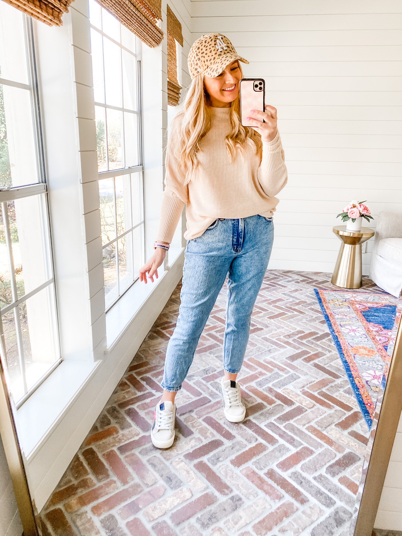 Fitting Room Finds by popular Houston fashion blog, Fancy Ashley: image of a woman wearing a Gibson tan sweater, jeans, white sneakers, and leopard print LA baseball cap.