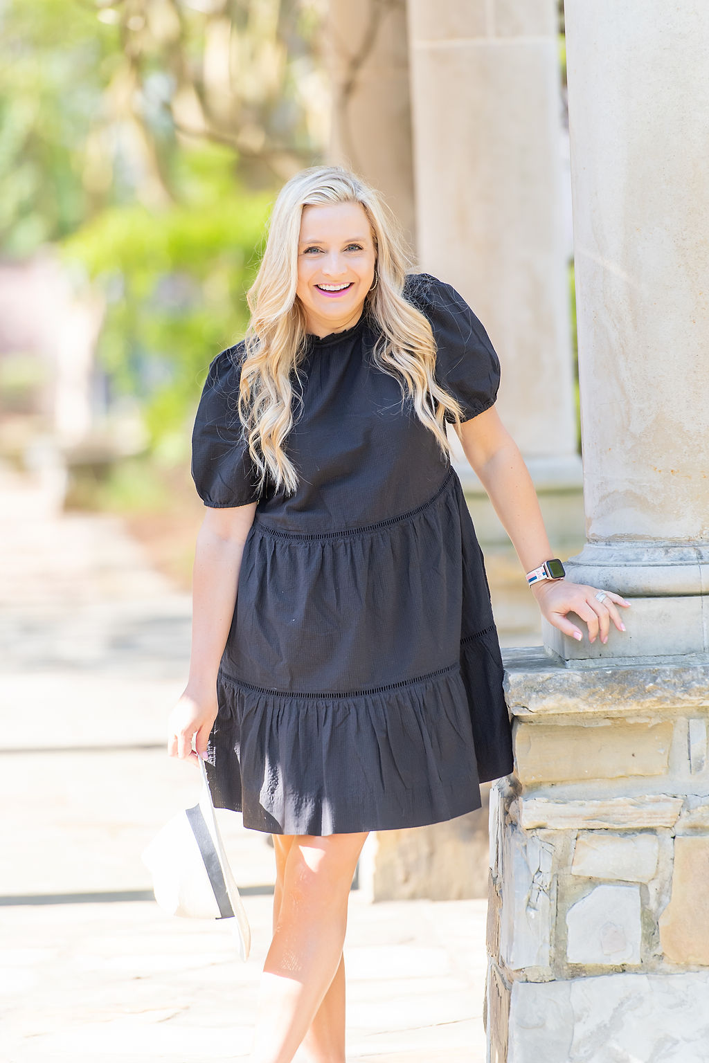 Little Black Dresses by popular Houston fashion blog, The House of Fancy: image of a woman wearing a black baby doll dress, white fedora hat, and studded strap sandals. 