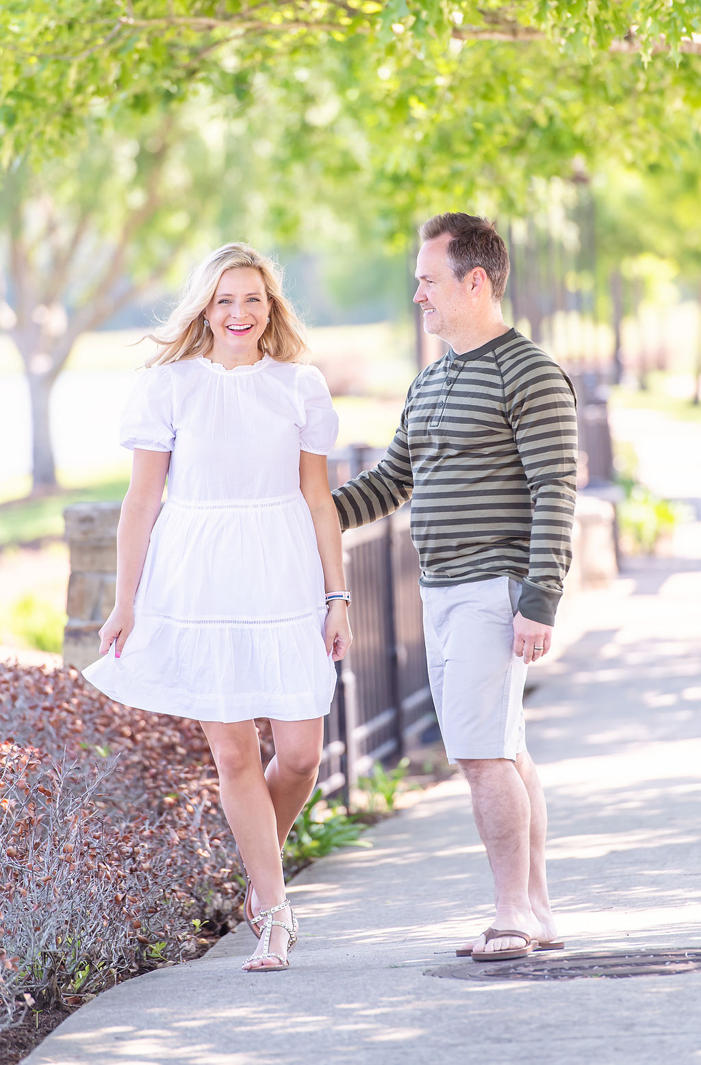 Walmart Summer Fashion by popular Houston fashion blog, The House of Fancy: image of a husband and wife standing together and wearing a white dress, green strip long sleeve shirt and tan shorts. 