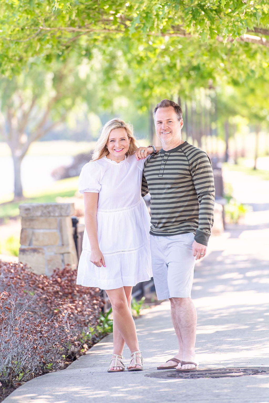 Walmart Summer Fashion by popular Houston fashion blog, The House of Fancy: image of a husband and wife standing together and wearing a white dress, green strip long sleeve shirt and tan shorts. 