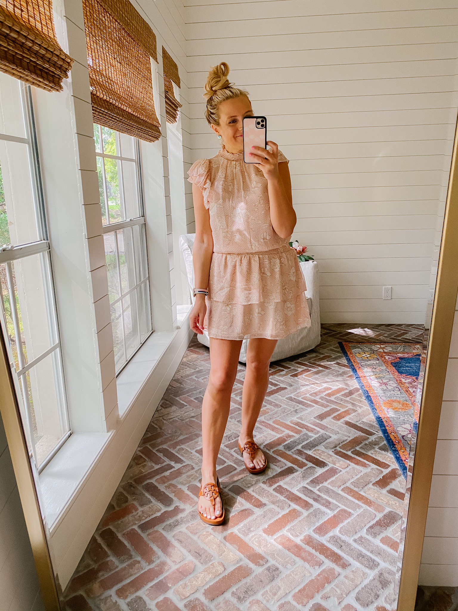 Express New Arrivals by popular Houston fashion blog, The House of Fancy: image of a woman wearing a Express peach colored floral print mock neck and tiered ruffle skirt mini dress with brown slide sandals. 