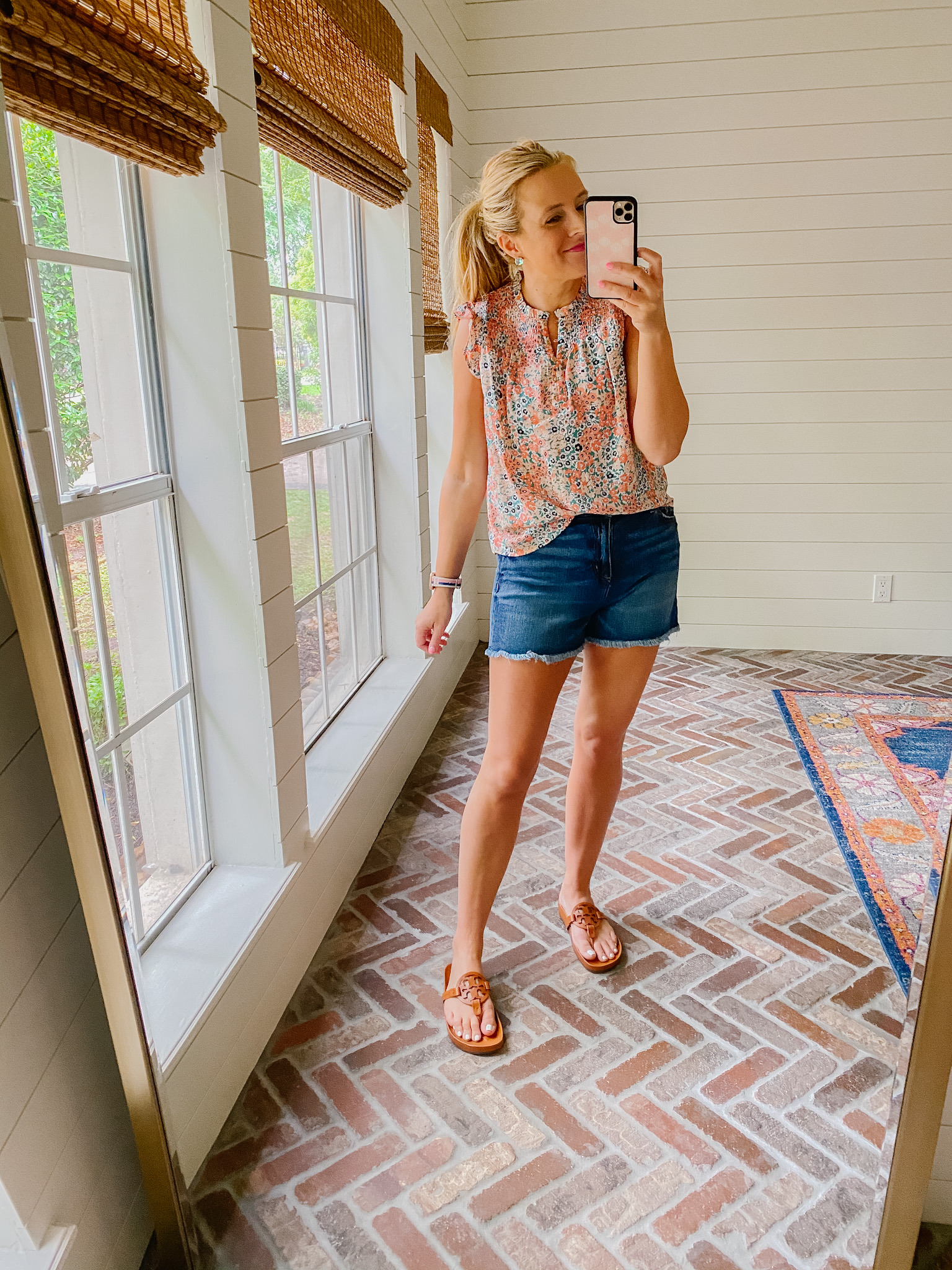 Loft Clothing by popular Houston fashion blog, The House of Fancy: image of a woman wearing a Loft floral print flutter sleeve top, distressed hem denim shorts, and brown Tory Burch slide sandals. 