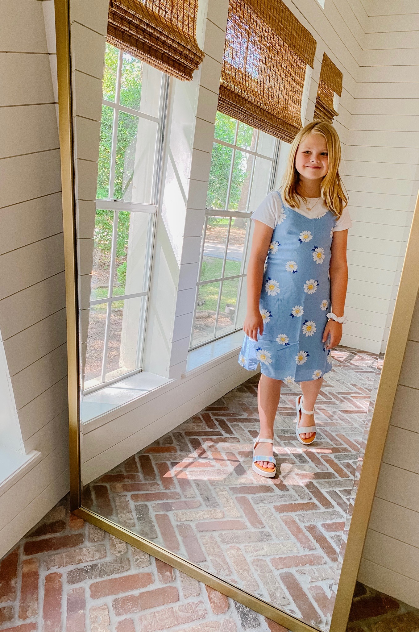 Spring Clothing by popular Houston fashion blog, The House of Fancy: image of a girl wearing a blue and white floral print dress, white t-shirt and metallic sandals. 