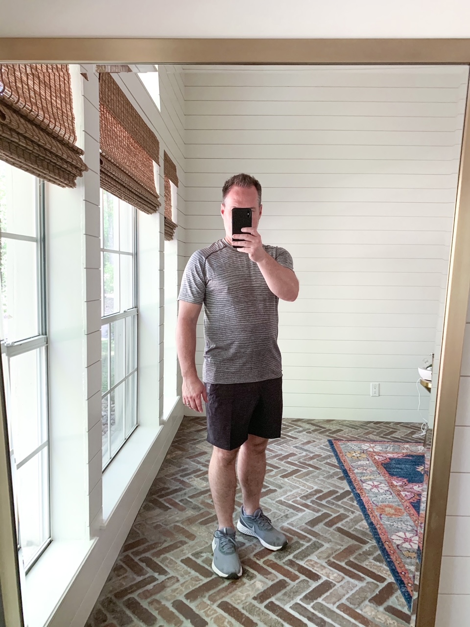 Men's Workout Gear by popular Houston fashion blog, The House of Fancy: image of a man wearing a Lululemon stripe shirt, Lululemon shorts and grey athletic shoes. 