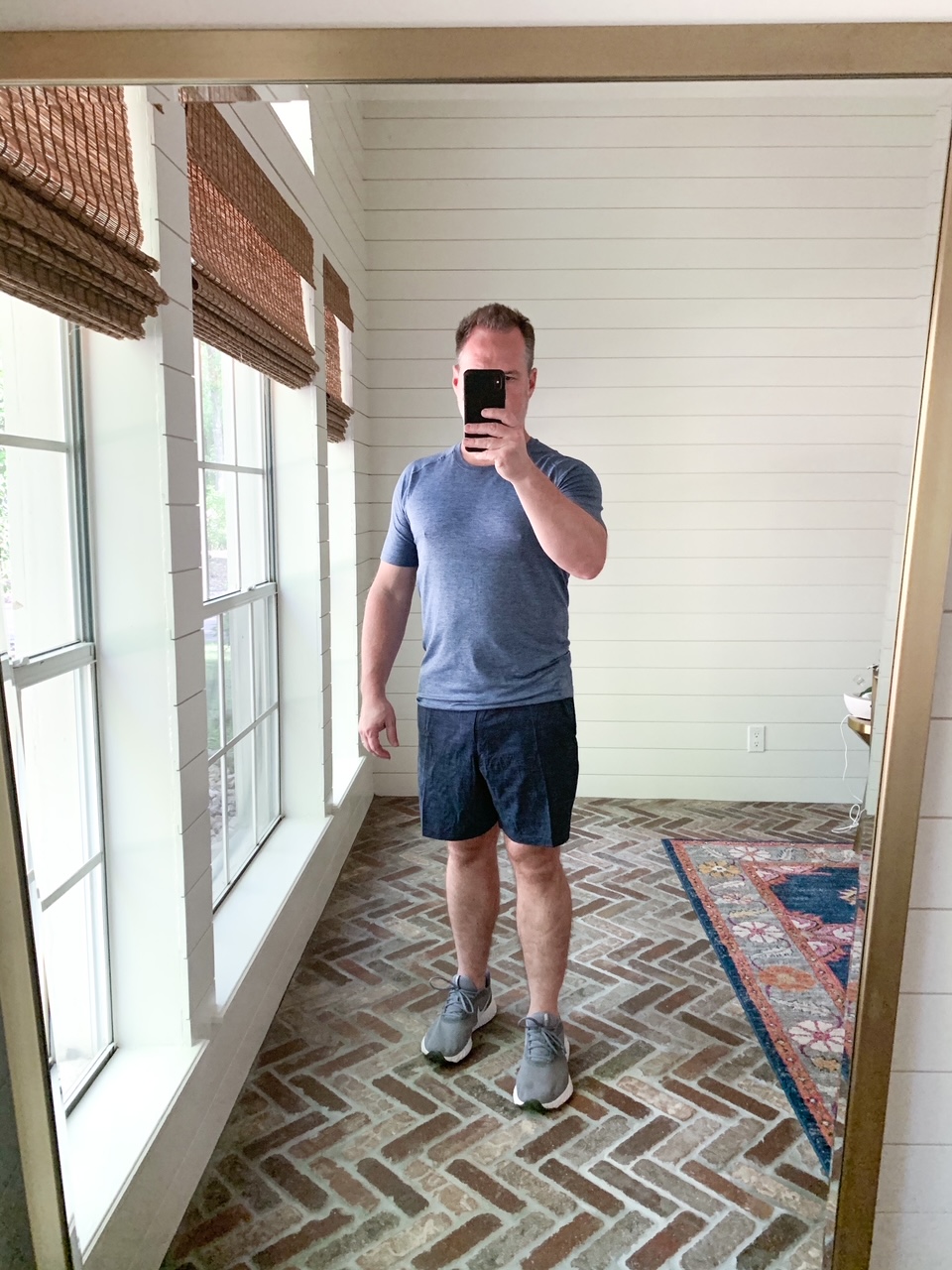 Men's Workout Gear by popular Houston fashion blog, The House of Fancy: image of a man wearing a Lululemon blue shirt, Lululemon shorts, and grey athletic shoes. 