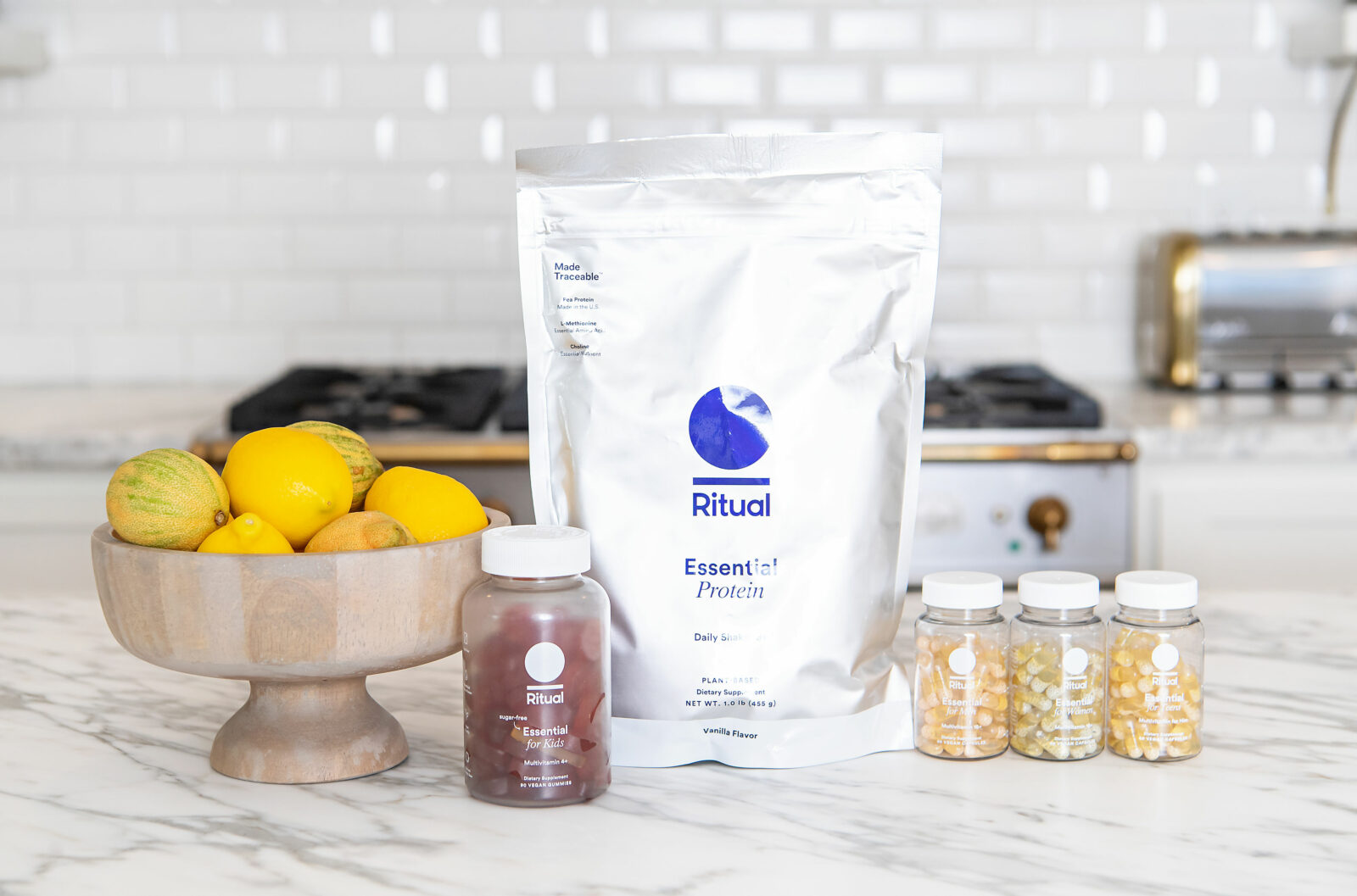 Healthy Living by popular Houston lifestyle blog, The House of Fancy: image of Ritual essential protein powder next to a wooden bowl of lemons and bottles of Ritual vitamins. 