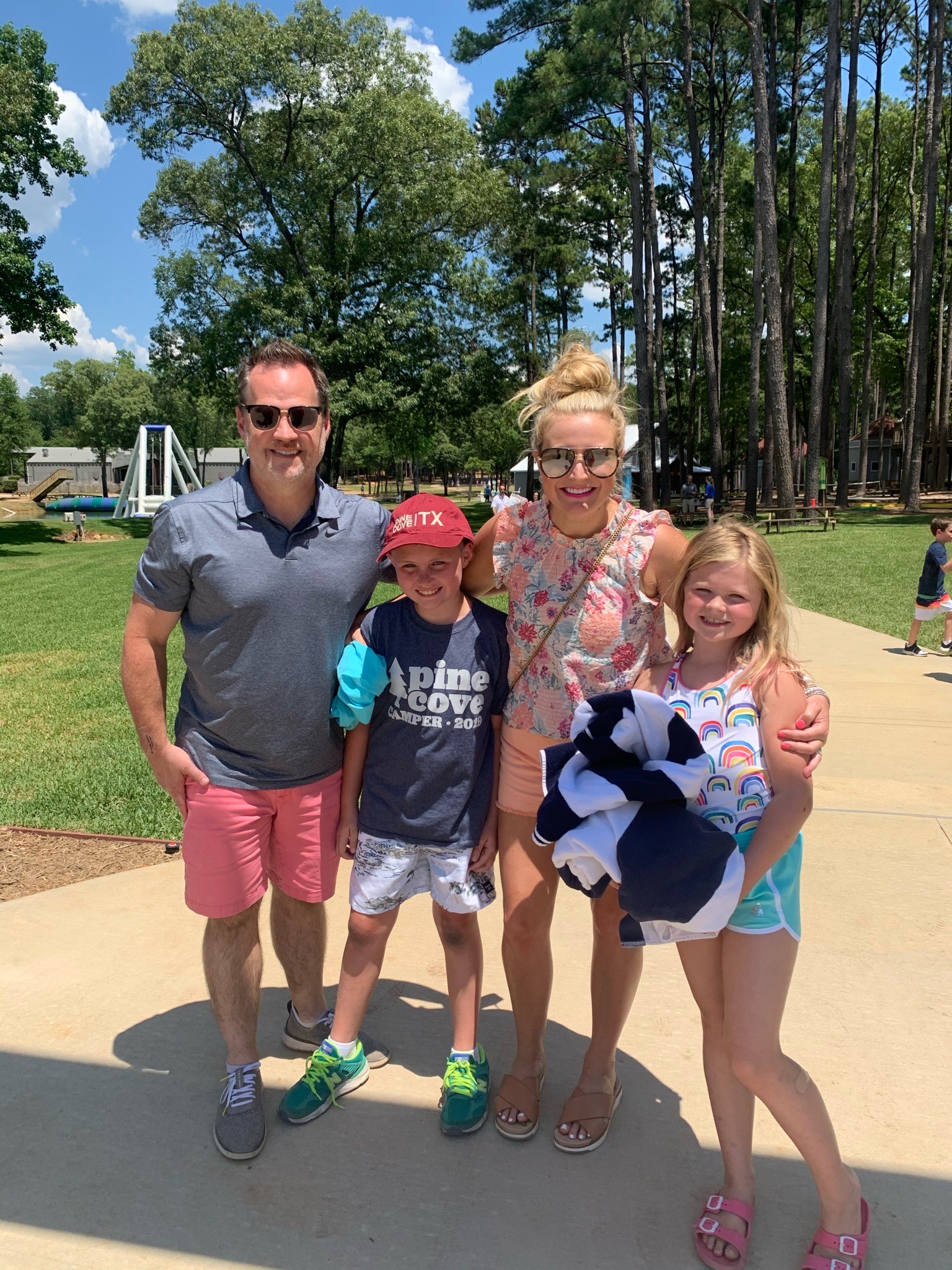 pack our kids for camp and the items we find essential! | Packing Tips by popular Houston lifestyle blog, The House of Fancy: image of a mom and dad and their son and daughter standing together outside at a summer camp. 